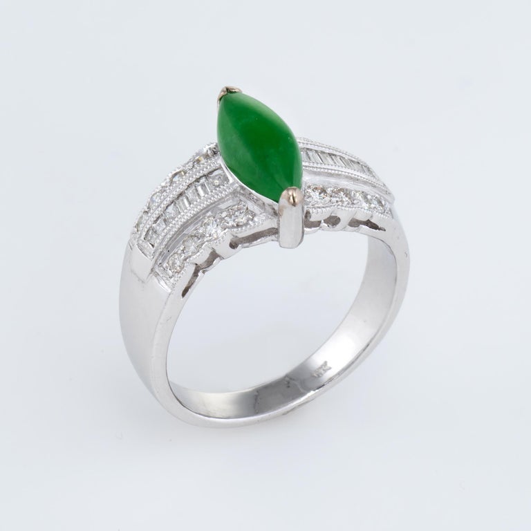 Elegant estate cocktail ring, crafted in 18 karat white gold. 

Cabochon cut marquise shaped jadeite jade measures 9.75mm x 4.75mm (estimated at 1 carat), accented with an estimated 0.30 carats of mixed cut (baguette and round brilliant) diamonds