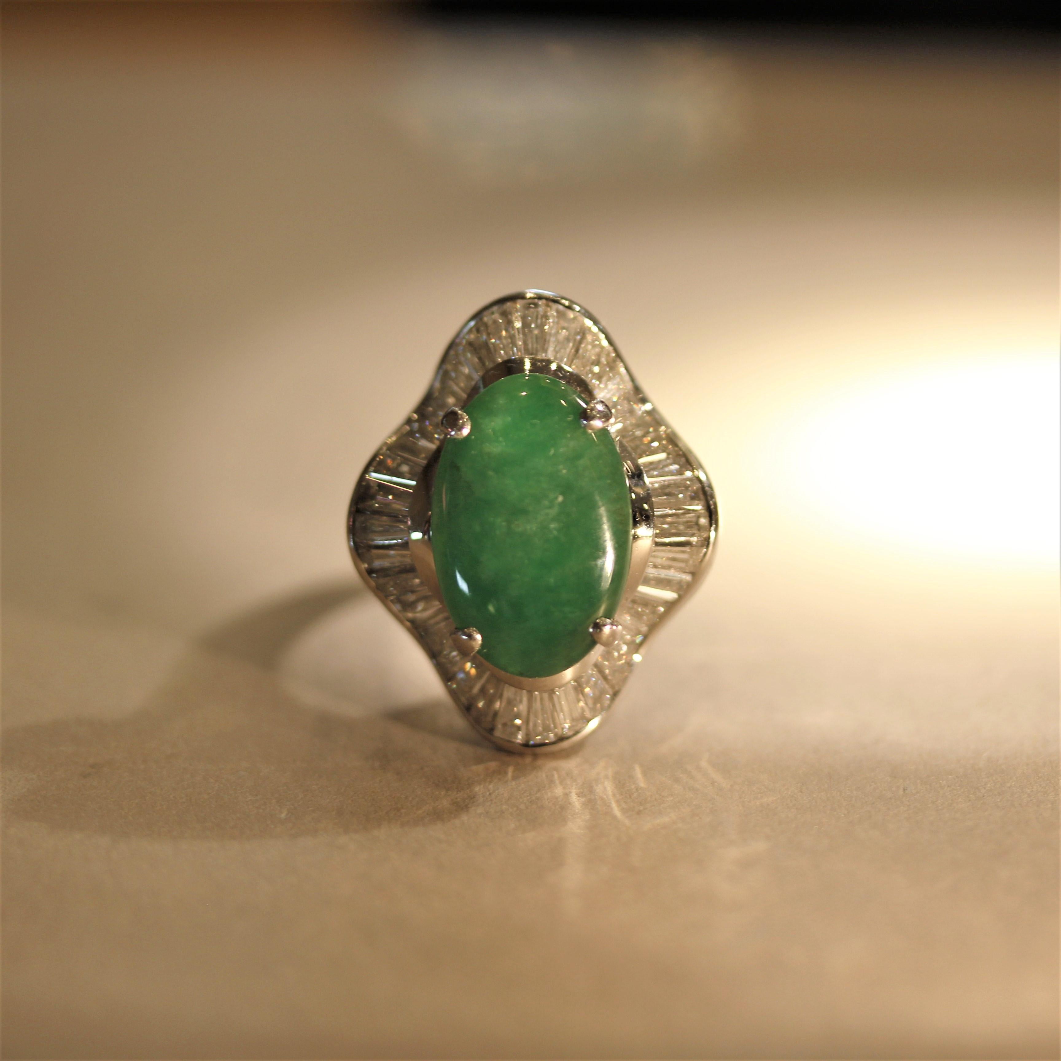 A large and impressive nature jadeite jade ring! The jade has a luscious deep green color with great luster as light rolls across the surface of the stone. It is accented by 3.02 carats of baguette-cut diamonds which are set around the jade in a