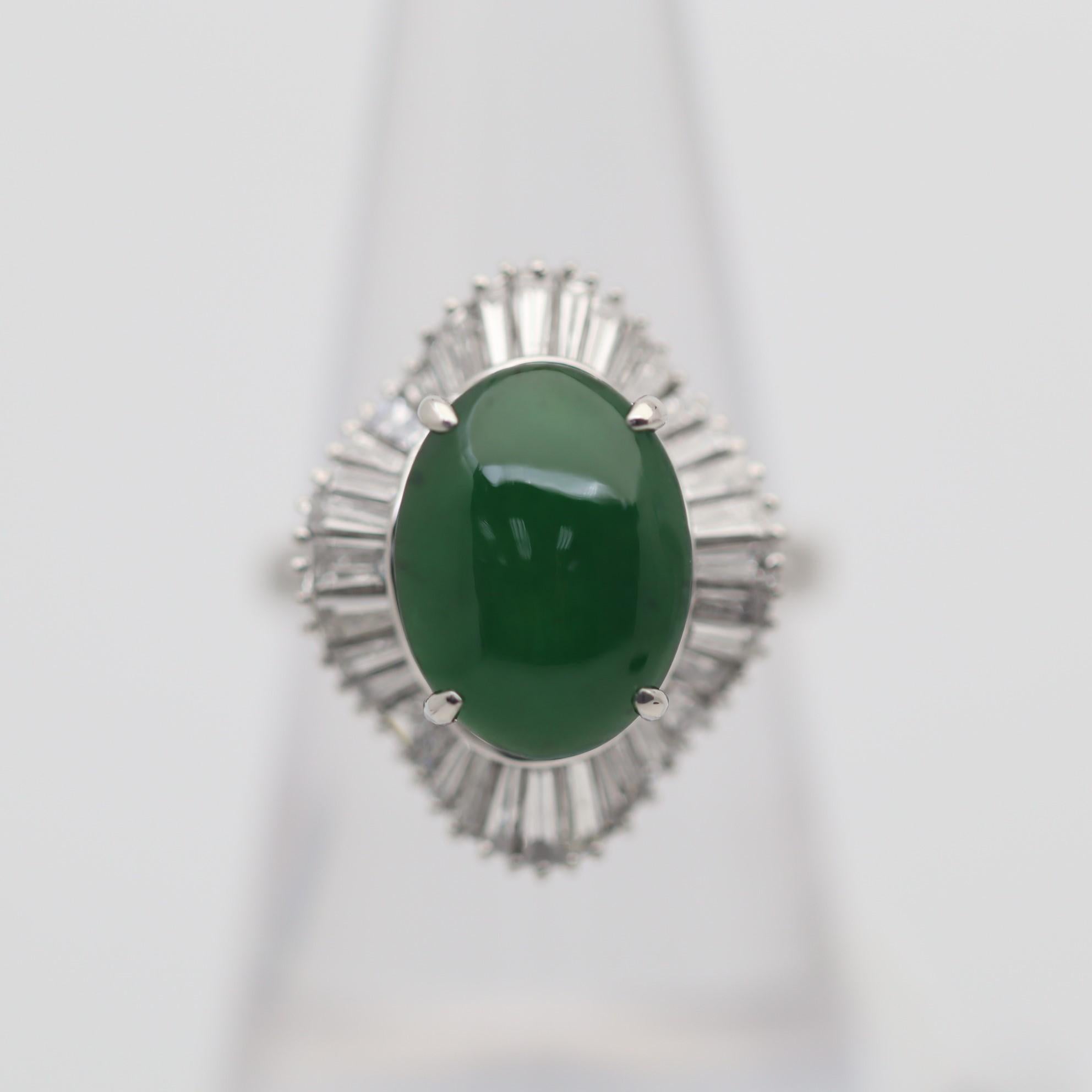 A finely made platinum ring featuring a fine piece of jadeite jade. The jade weighs 2.75 carats and has a rich deep grass green color. It is accented by 1.39 carats of baguette-cut diamonds which surround the jade in a ballerina style.