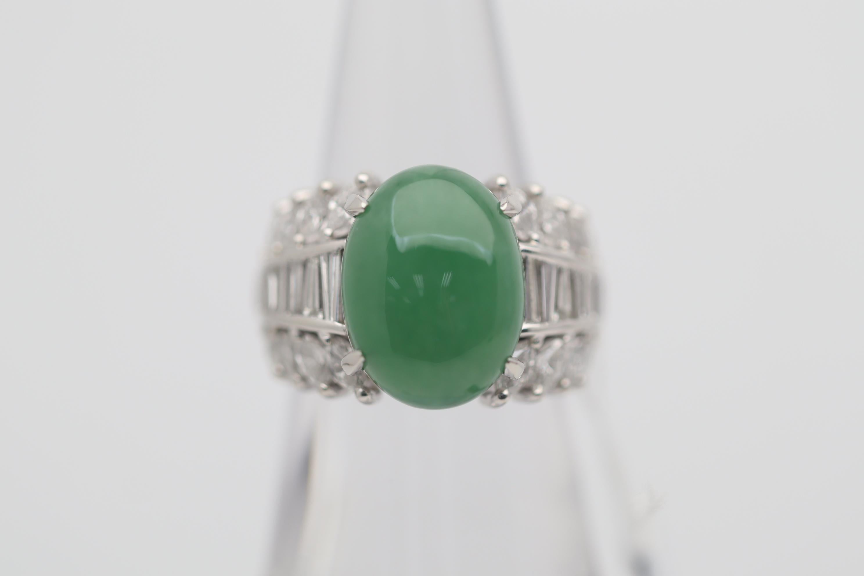 A strong and stylish platinum ring featuring an 8.59 carat jade. It has a pleasing even green color and a smooth domed cabochon finish. It is complemented by 1.88 carats of marquise and baguette-cut diamonds which are set on its sides in a stylish