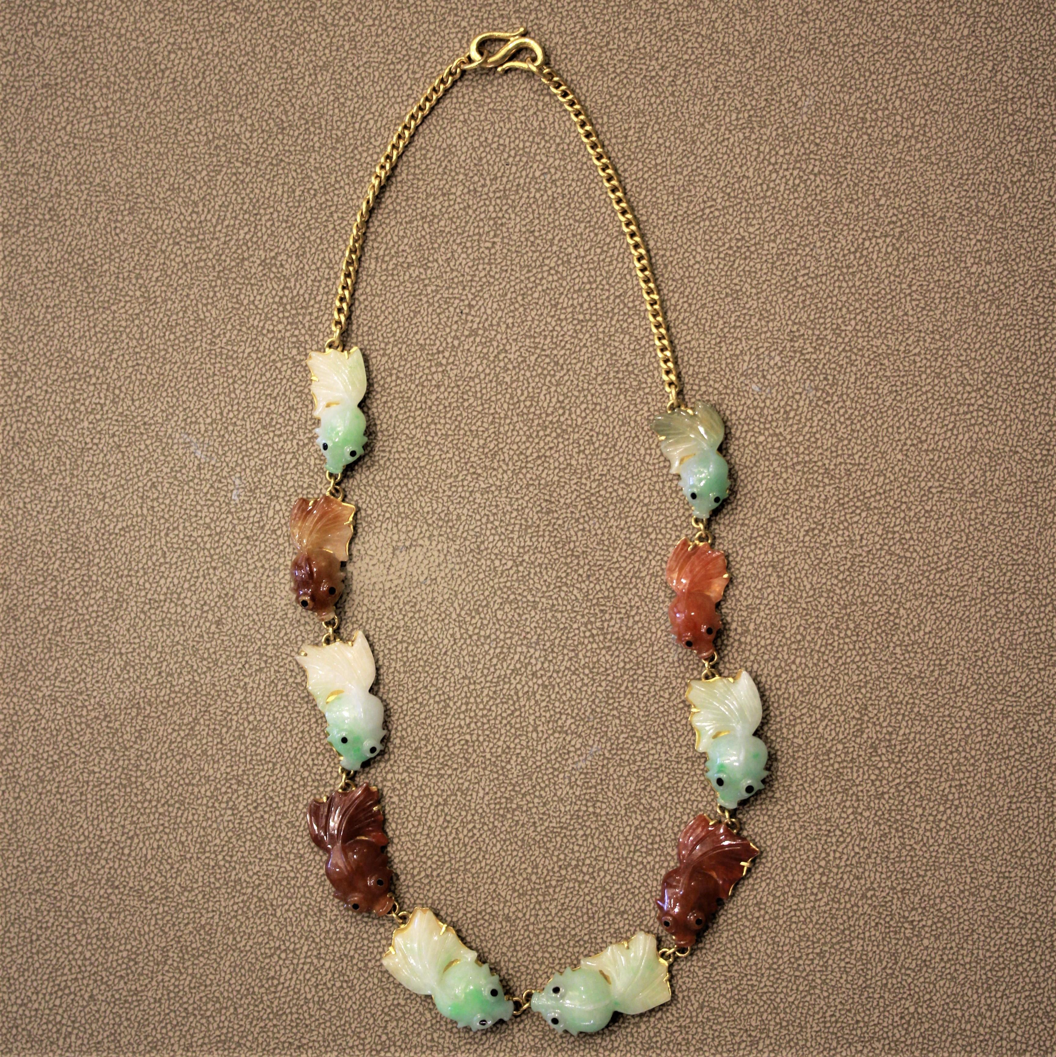 A unique necklace featuring 10 pieces of jade carvings for fanciful fish! Six of them are green while the other four are an orangy-red colored jadeite jade. The necklace was made using 22k gold, as it can be seen in the color of the gold. The clasp,