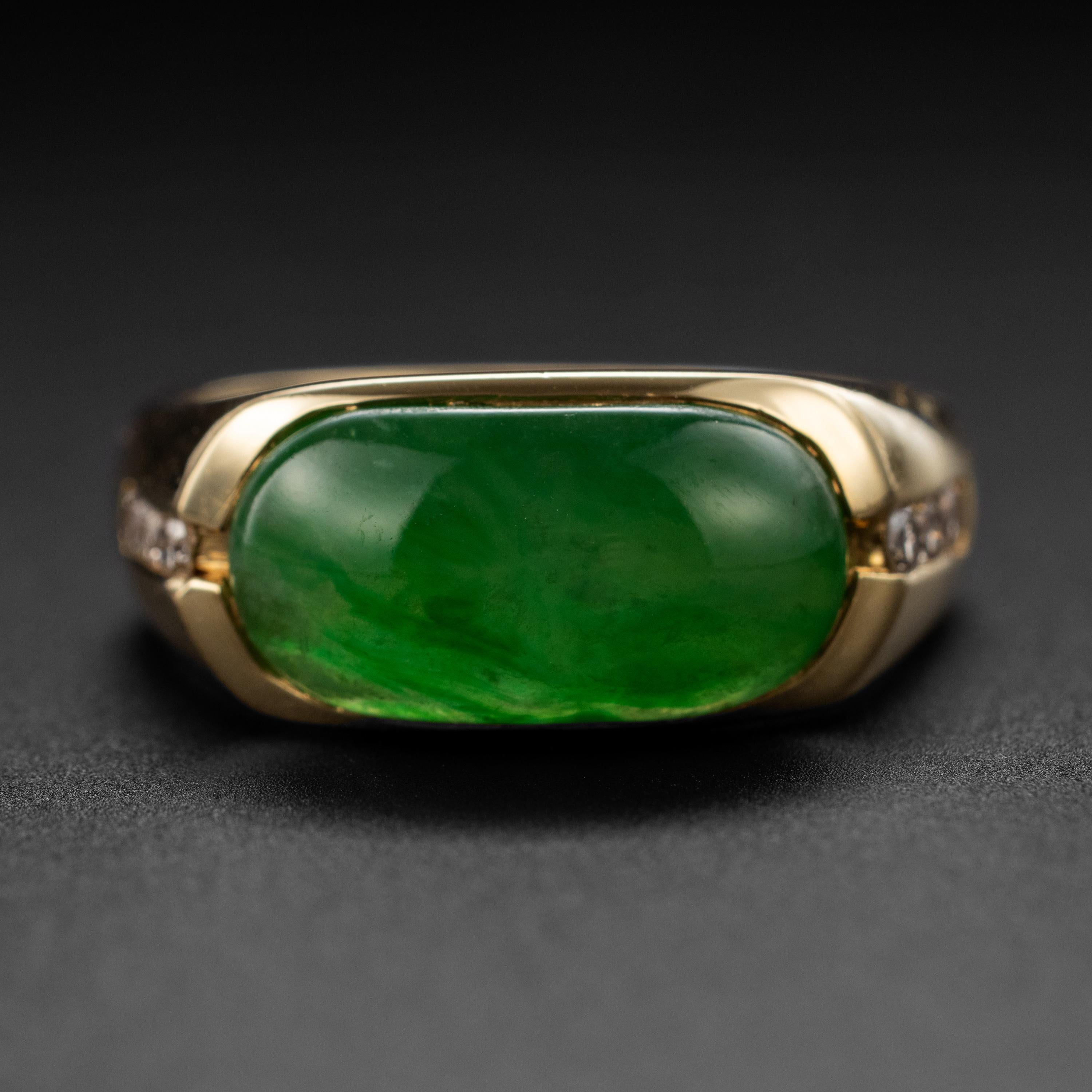 This classic and substantial jade saddle ring features a vivid, highly translucent cabochon of certified untreated emerald green Burmese jadeite jade that is cut into the rectangular 