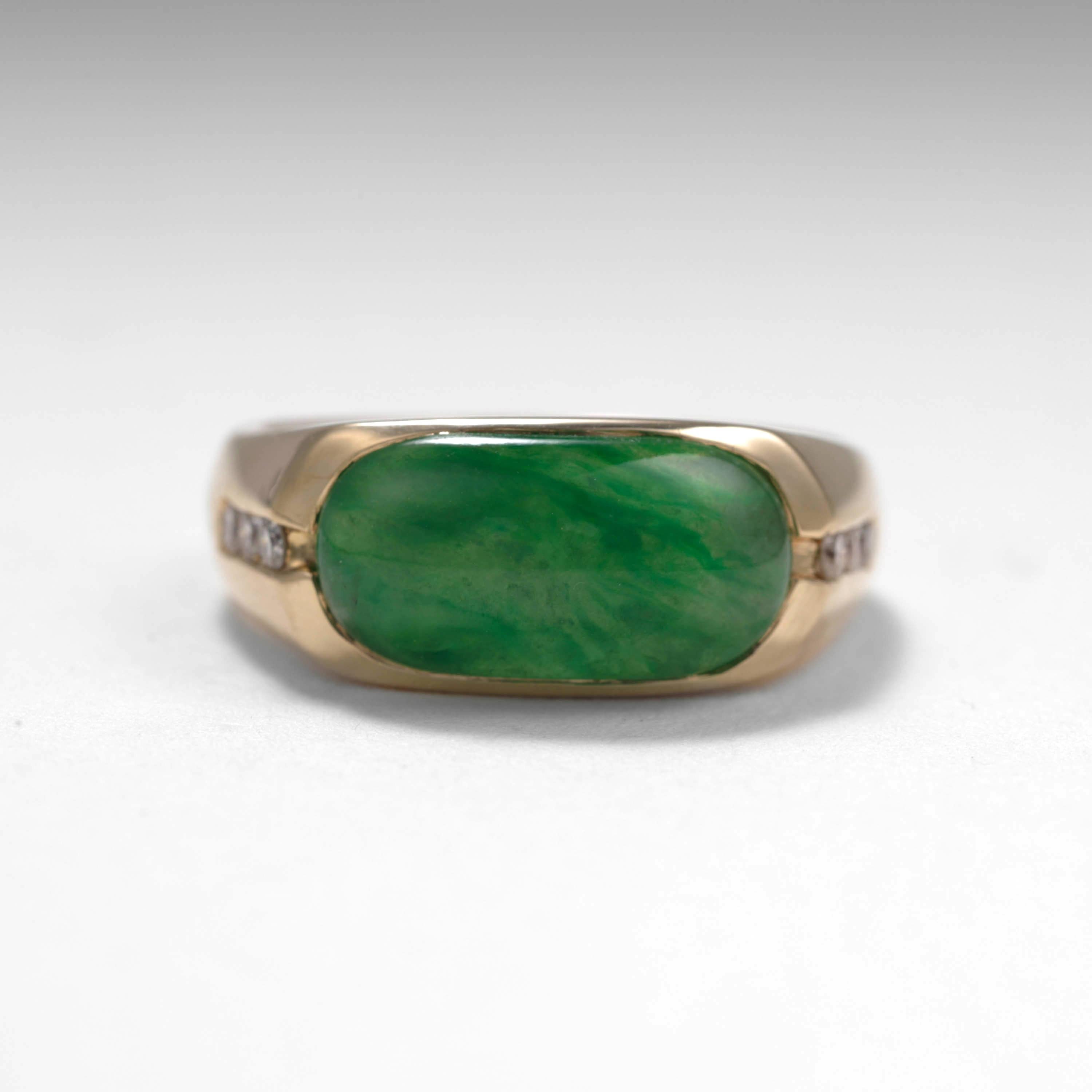 This classic and substantial jade saddle ring features a vivid, highly translucent cabochon of certified untreated emerald green Burmese jadeite jade that is cut into the rectangular 