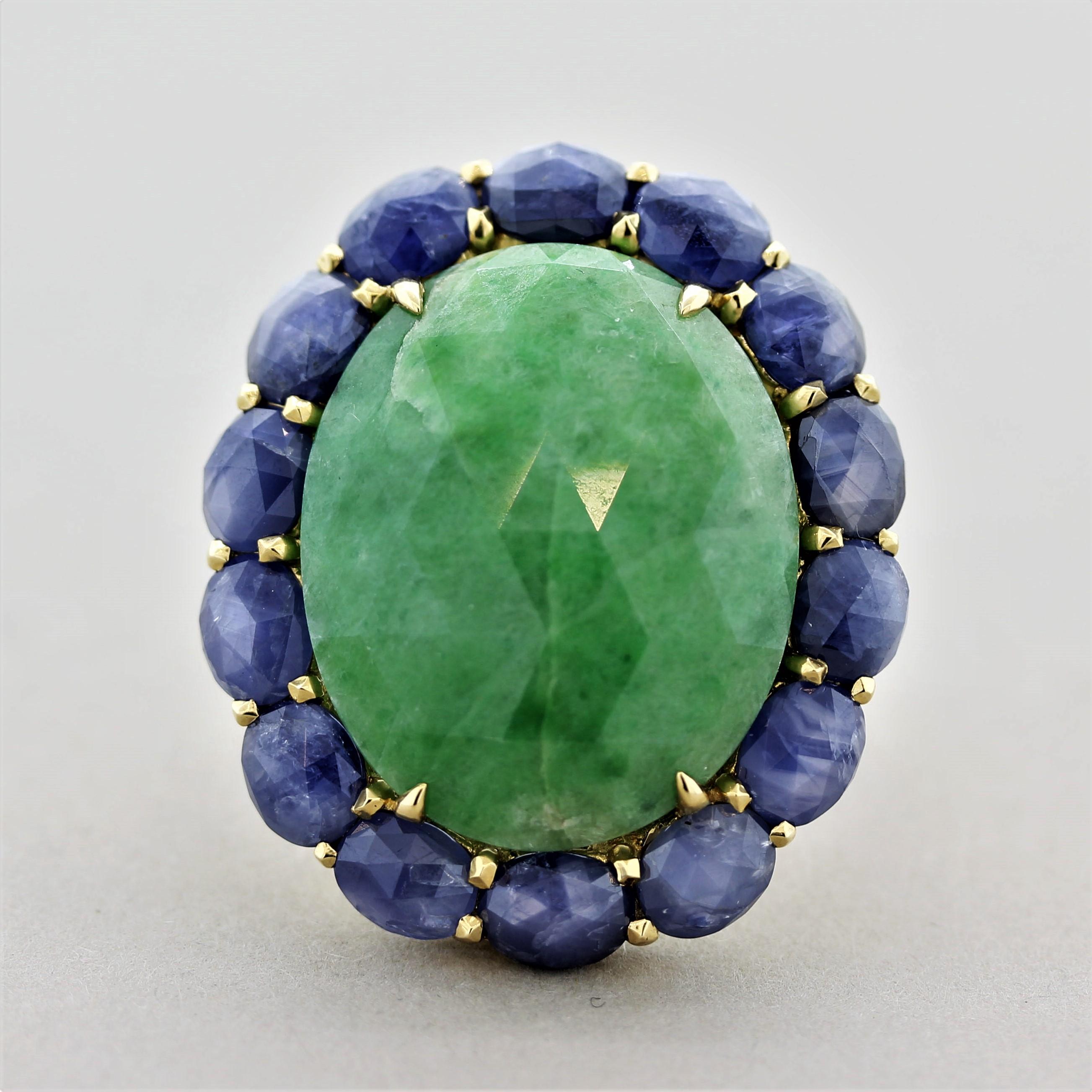 A large and impressive ring featuring a 28.25 carat jade with a unique rose-cut on its top. It is accented by 10.89 carats  of blue sapphires which are set around the jade and are also rose-cut. Made in 18k yellow gold and ready to be worn! 
Ring