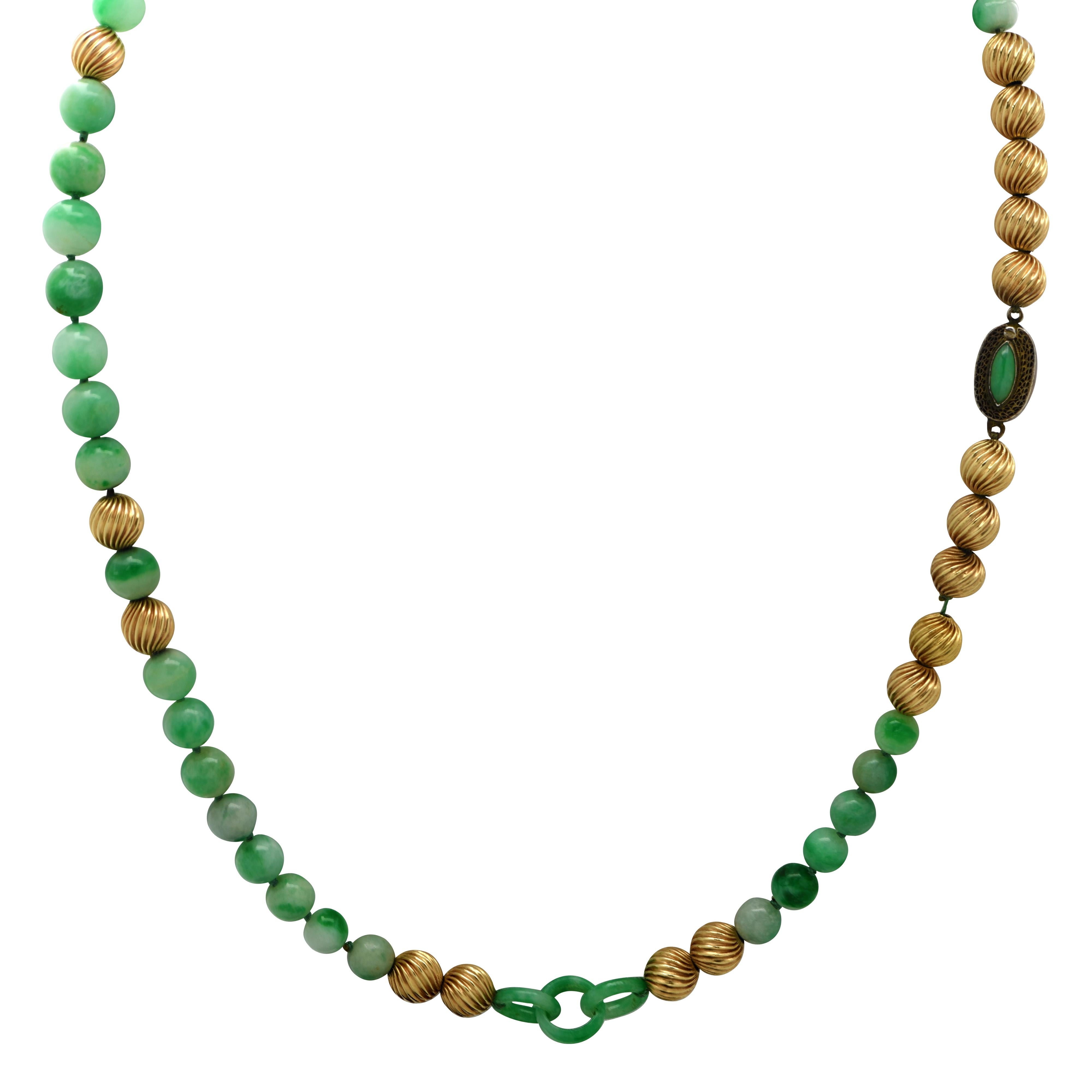 Gorgeous Jadeite Bead necklace featuring 37 jadeite beads, graduating in size from 3mm to 4mm, interspersed with 22 yellow gold fluted beads and interlocking jade rings, with a silver hidden box clasp set with a marquise shape jade cabochon. This