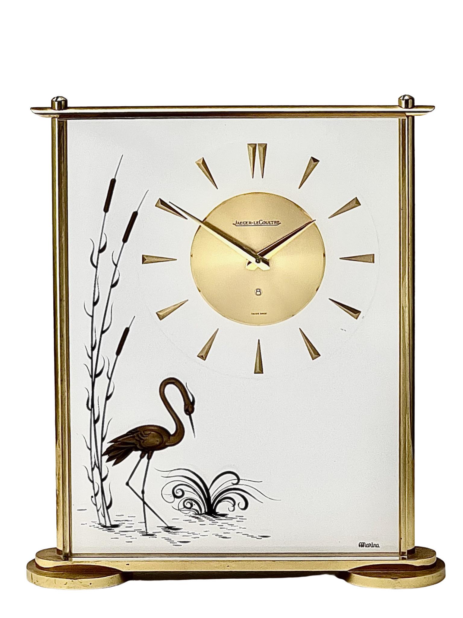 A stylish Mid-Century Jaeger-LeCoultre mantel clock in a lucite case showing a beautiful scene from nature with a heron fishing amongst reeds. Numbered 487, the clock has an eight day movement.

Beautifully framed by a gilt brass frame, the dial has