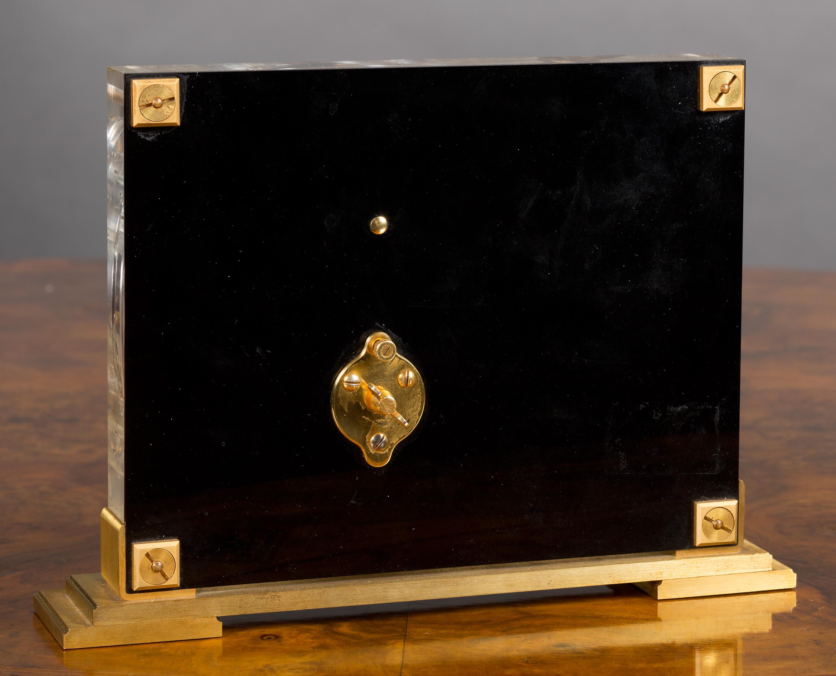 Jaeger-LeCoultre Mystery Clock in einem Lucite-Gehäuse mit wunderschönem Chinoiserie-Dekor, das einen Vogel im Flug zeigt und auf einem vergoldeten Stufensockel steht.

Acht-Tage-Uhrwerk 'in line' von Jaeger-LeCoultre mit Stabindexen und