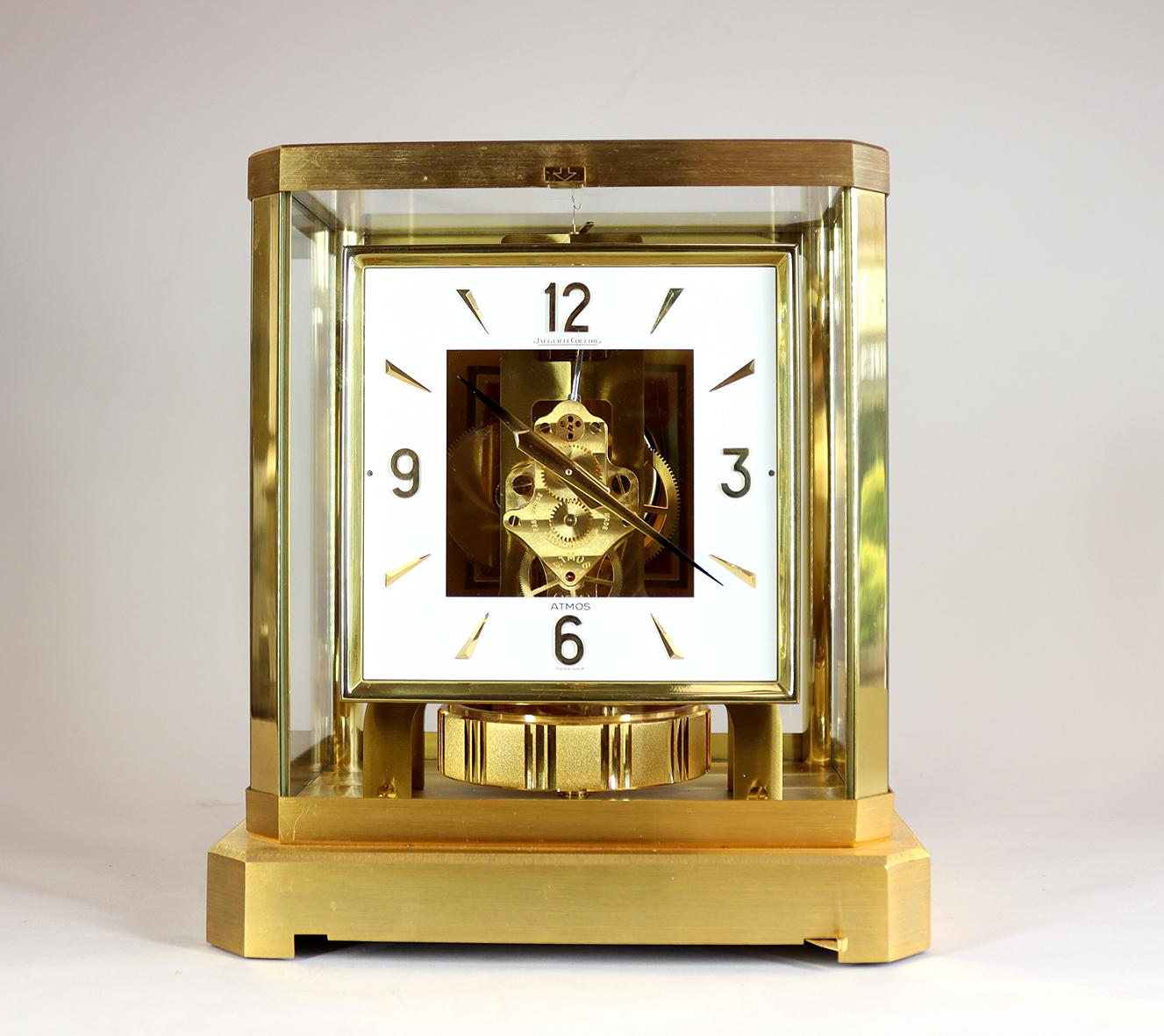 A beautiful Atmos Clock By Jaeger LeCoultre numbered 321410, with a square dial with gilded Arabic numerals and battens and smoked tip hands. Unusually this clock still has it’s original gilded wall bracket finished in a combination or grained and