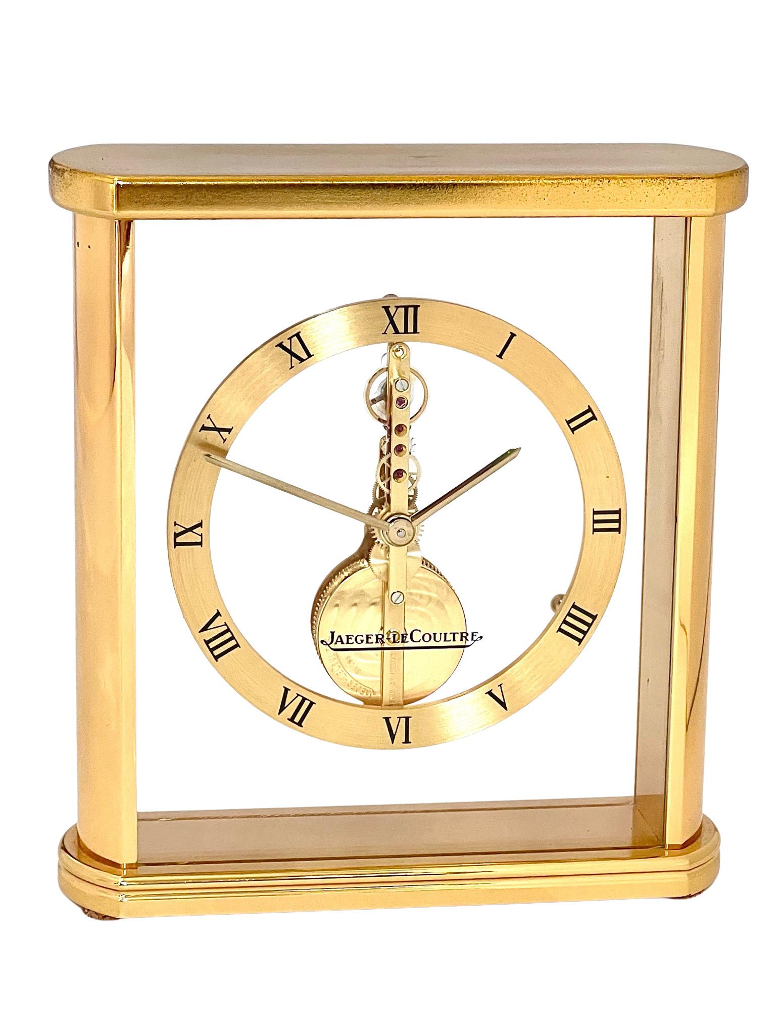 A stylish brass and glass mantel clock by Jaeger LeCoultre, with a floating Baguette movement set in a rectangular glass and polished brass case. 

Jaeger reference is 215.023. The logo is visible and lends a stylish aesthetic to the clock. The