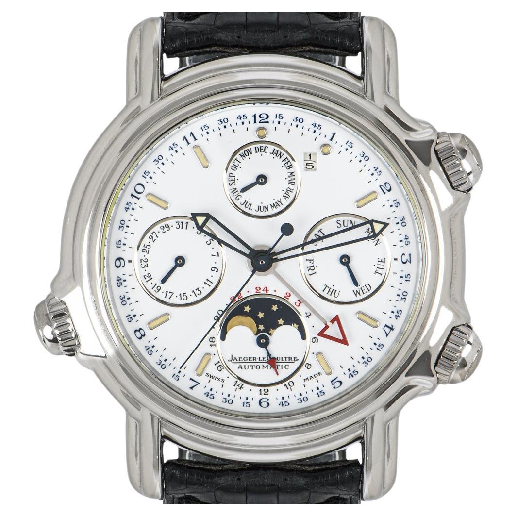 An exclusive men's Grand Reviel wristwatch crafted in platinum by Jaeger-LeCoultre. Featuring a white dial with skeletonised blued steel sword hands, a red alarm hand, and four subdials displaying a moon phase, weekday, month, and date.