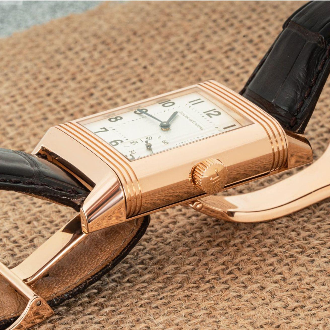 A 29mm rose gold Jaeger LeCoultre Grande Reverso wristwatch. Featuring a silver guilloche dial with a small seconds sub-dial, blue steeled sword-shaped hands and a reversible side which features a power reserve indicator.

Equipped with a Jaeger