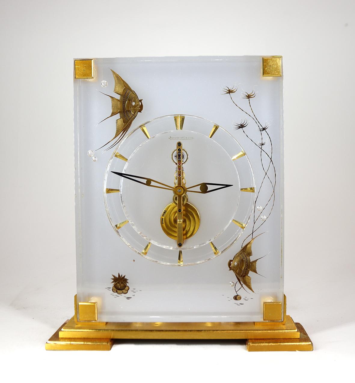 A rare inline skeleton timepiece by Jaeger-LeCoultre, with a gilded 16 jewel ‘baguette’ eight day movement. The case is made of Lucite a crystal clear type of acrylic that has been hand carved and reverse painted to create three dimensional fish