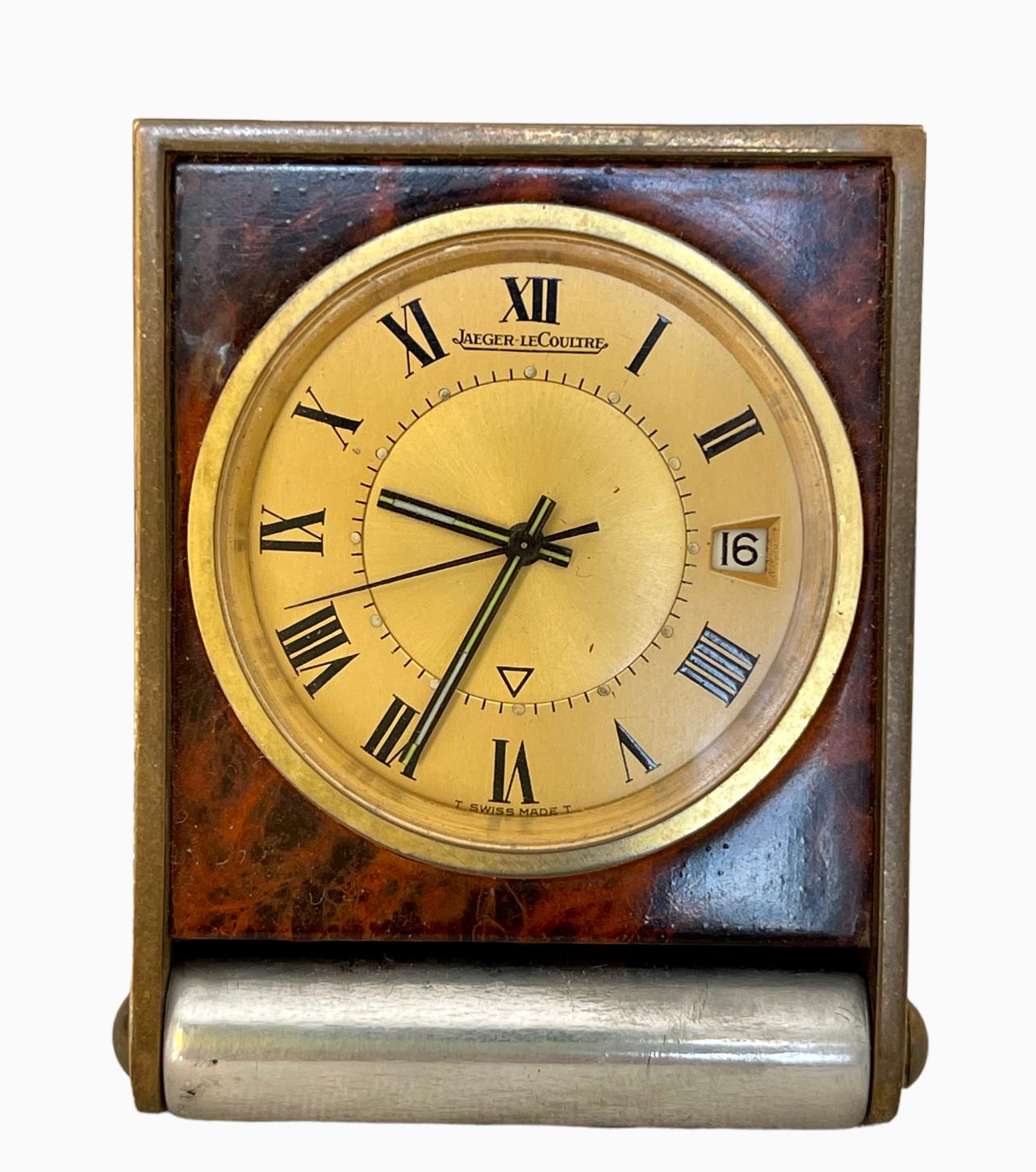 Pocket travel clock from Maison Jaeger-Lecoultre. It is in silver metal with a gold dial on a brown tortoiseshell background. Manual winding movement caliber 911. It works perfectly and has an alarm function. This clock dates from the 70s, is in