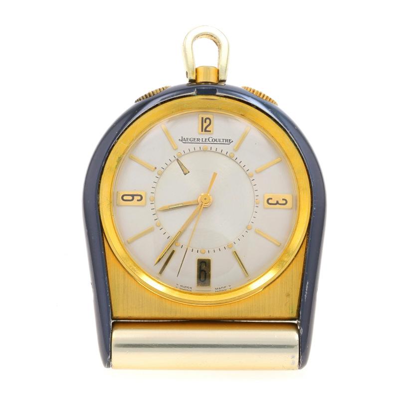 Brand: Jaeger LeCoultre
Model: Memovox Travel Alarm Clock
Movement: Manual
Movement Maker: Swiss
Dial Color: Silver

Metal Content: Gold Toned & Silver Toned

Features: 
Numbers marking the 12, 3, 6, & 9 o'clock hours 
Dashes marking the remaining