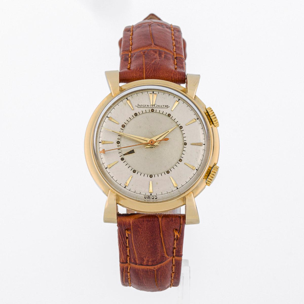 Reloj de pulsera Jaeger LeCoultre Memovox. Se trata de una pieza vintage con un diseño de caja único, con asas curvadas. Tiene función de alarma. La caja está chapada en oro y mide 32 mm de diámetro sin las asas. Viene con una correa de cuero