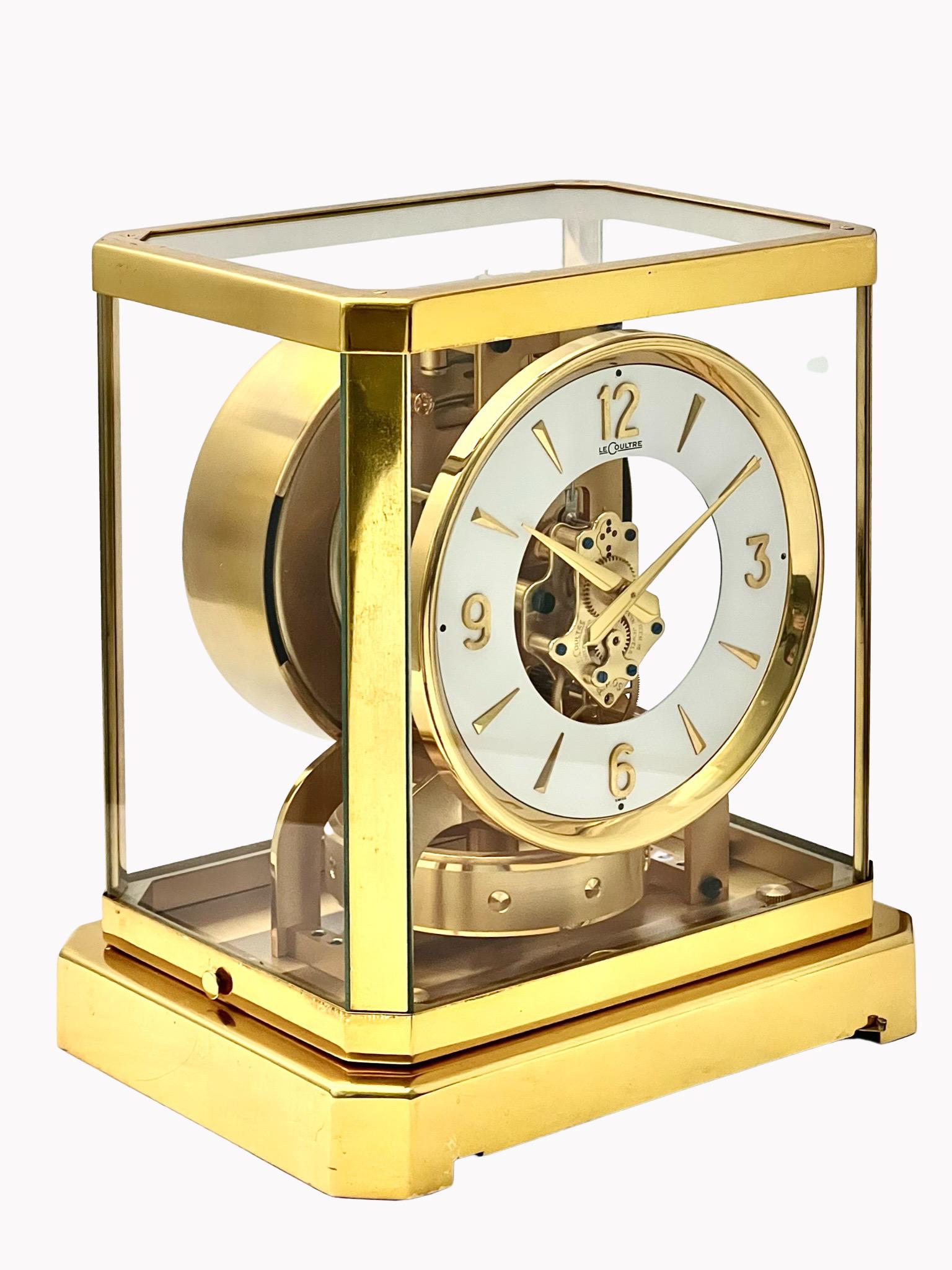 A stunning mid-century Jaeger LeCoultre gilt brass Atmos clock with circular dial and Arabic numerals. The ring-shaped balance appears to float in the air. The clock is silent and never needs winding. This classic clock in its gilded cabinet is a