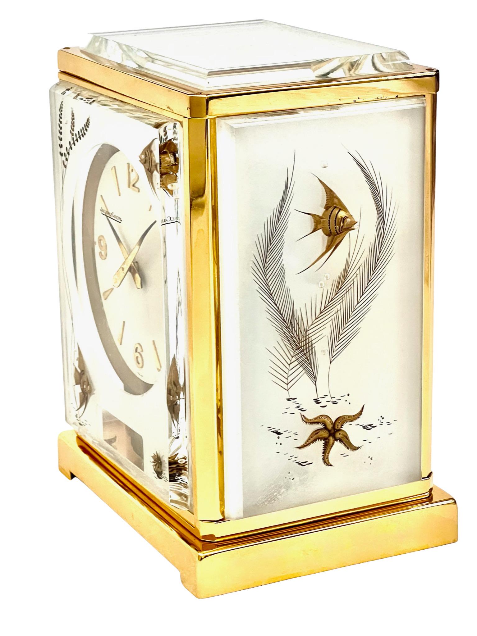 A stunning Jaeger LeCoultre mid-century Marina 'Poissons' Atmos clock with gilded fishes to the front and sides. This piece looks wonderful on a desk in a study, or on a mantelpiece or table.

The Atmos is a clock that has no external power source