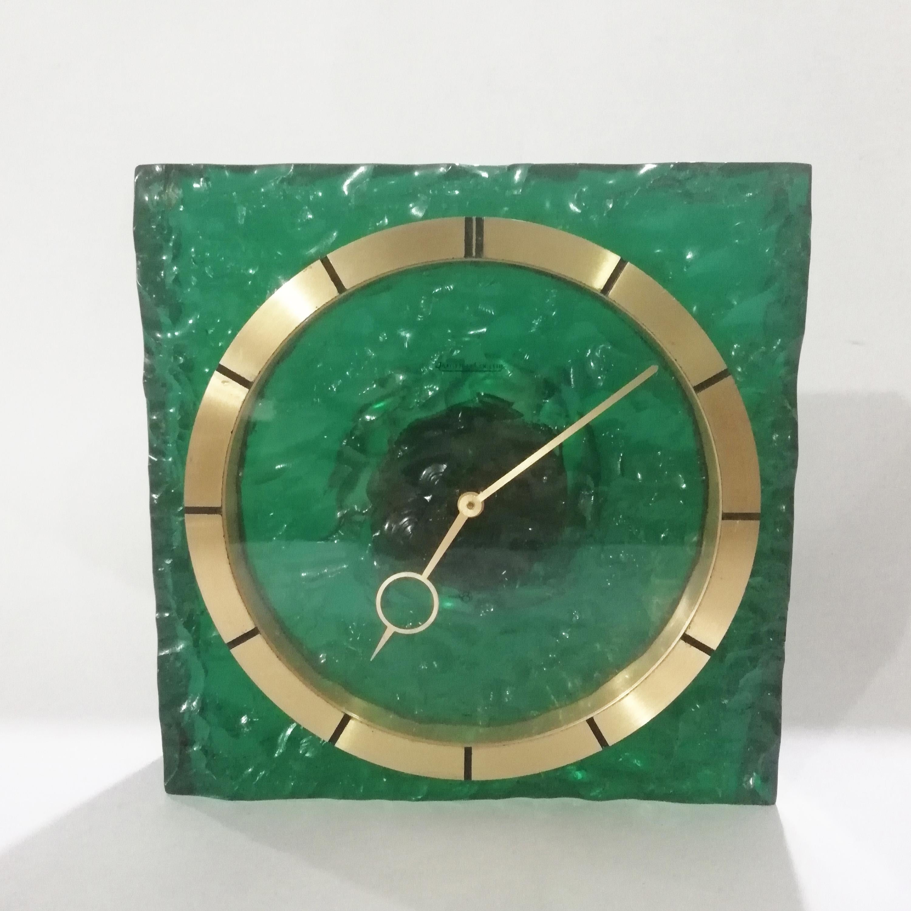 Rare Mid-Century Modern green resin and brass table clock by Swiss manufacturer Jaeger-LeCoultre. The green transparent resin case shows a stony texture. The brass bezel shows fluted indicators and an acrylic face. Baton brass hands. 50 milimeter