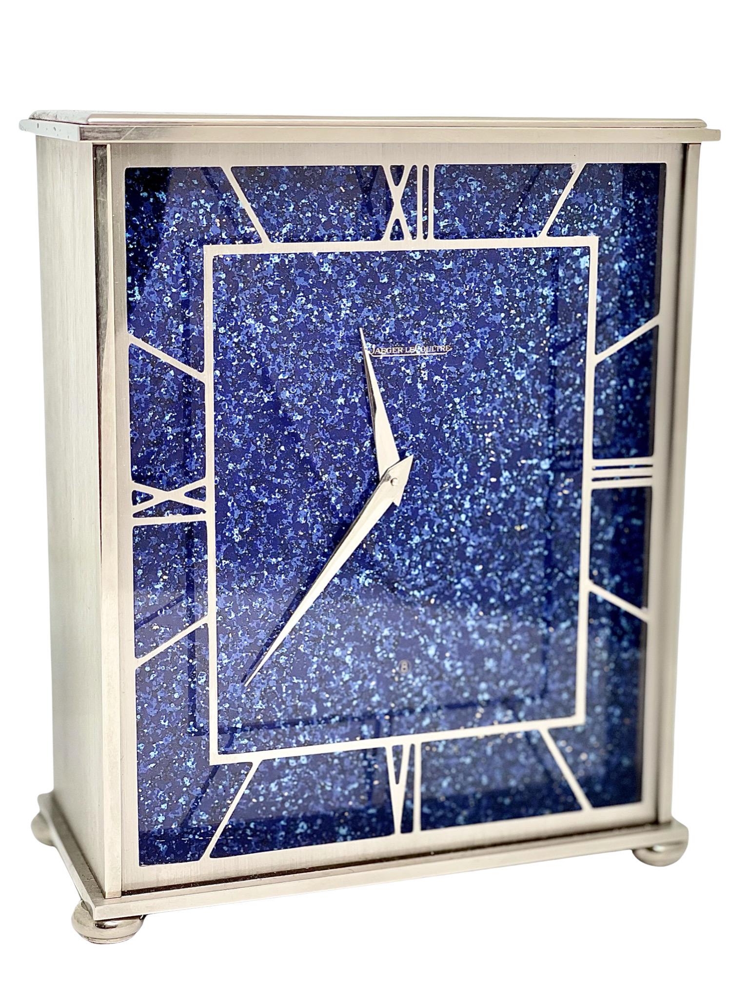 A beautiful mid-century rhodium-plated Lapis Lazuli effect eight day timepiece mantel clock made by Jaeger LeCoultre, La Chaux-de-Fons, Switzerland.

Mid-century clocks make stunning statements in your home. They blend extremely well with any