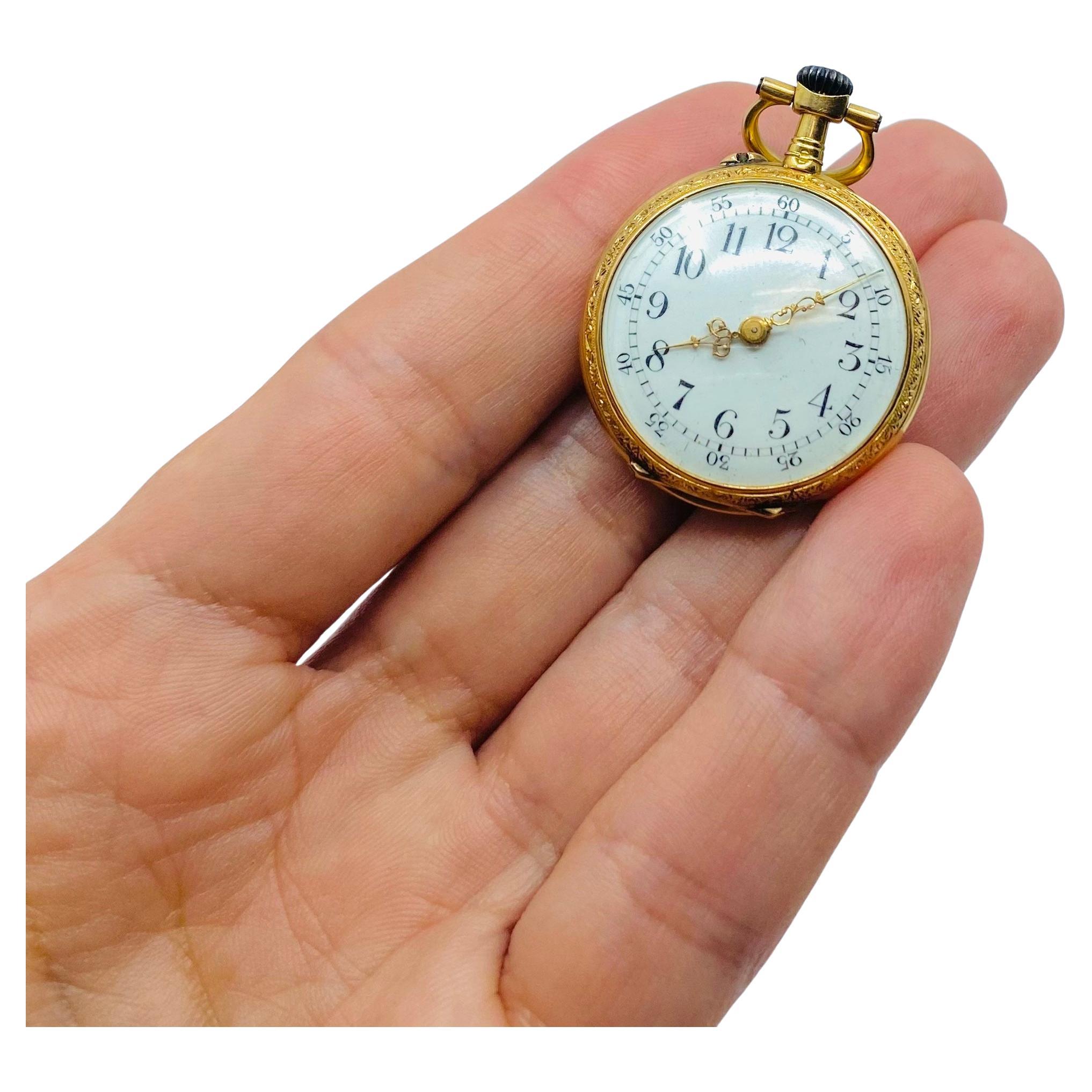 A Jaeger-LeCoultre pendant pocket watch made in 14k gold, features enamel and a diamond.
The back of this antique watch decorated with a fantastic enamel and gold filigree work. Deep red enamel contrasted by the bright yellow gold provides a