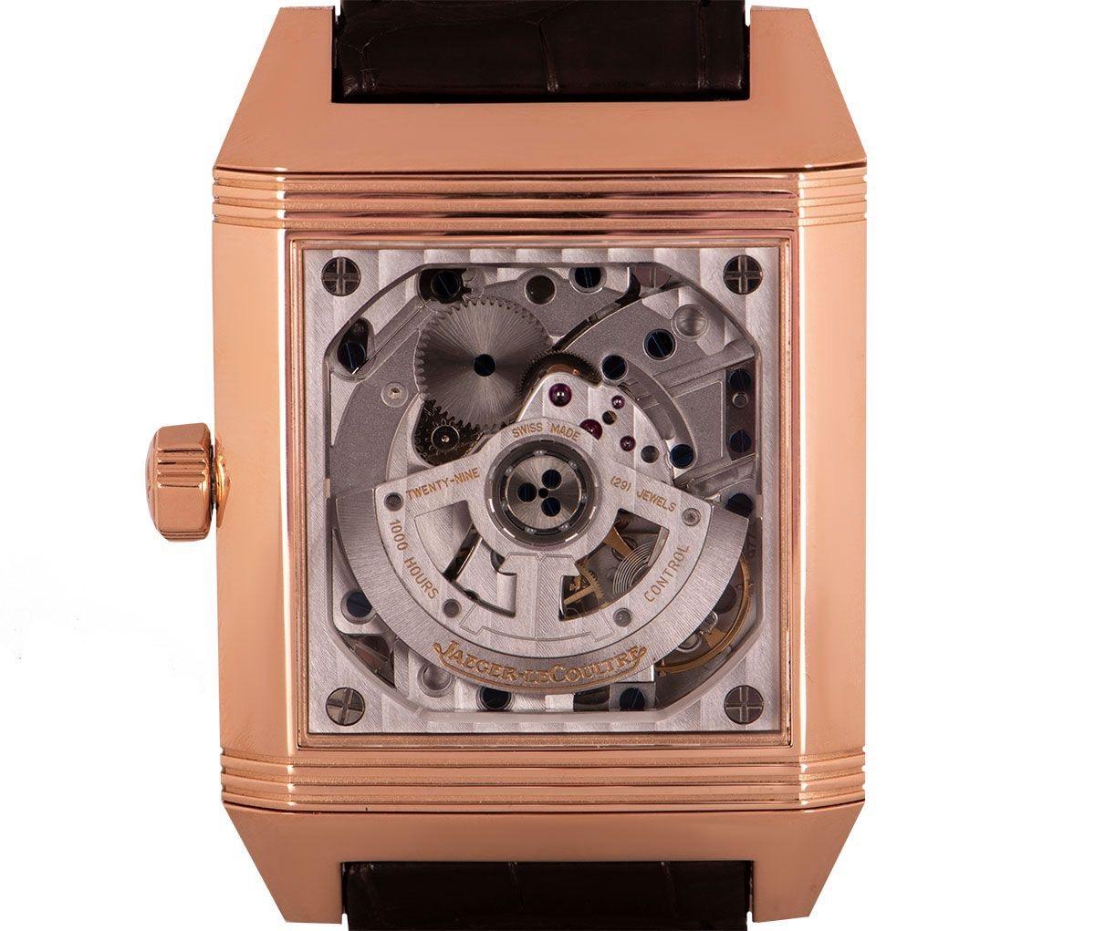 A 35 rose gold Reverso Squadra Hometime by Jaeger LeCoultre, featuring a silver dial with the date, small seconds and an AM/PM indicator. The reverse side has an exhibition case back which shows the watches automatic movement. An original brown