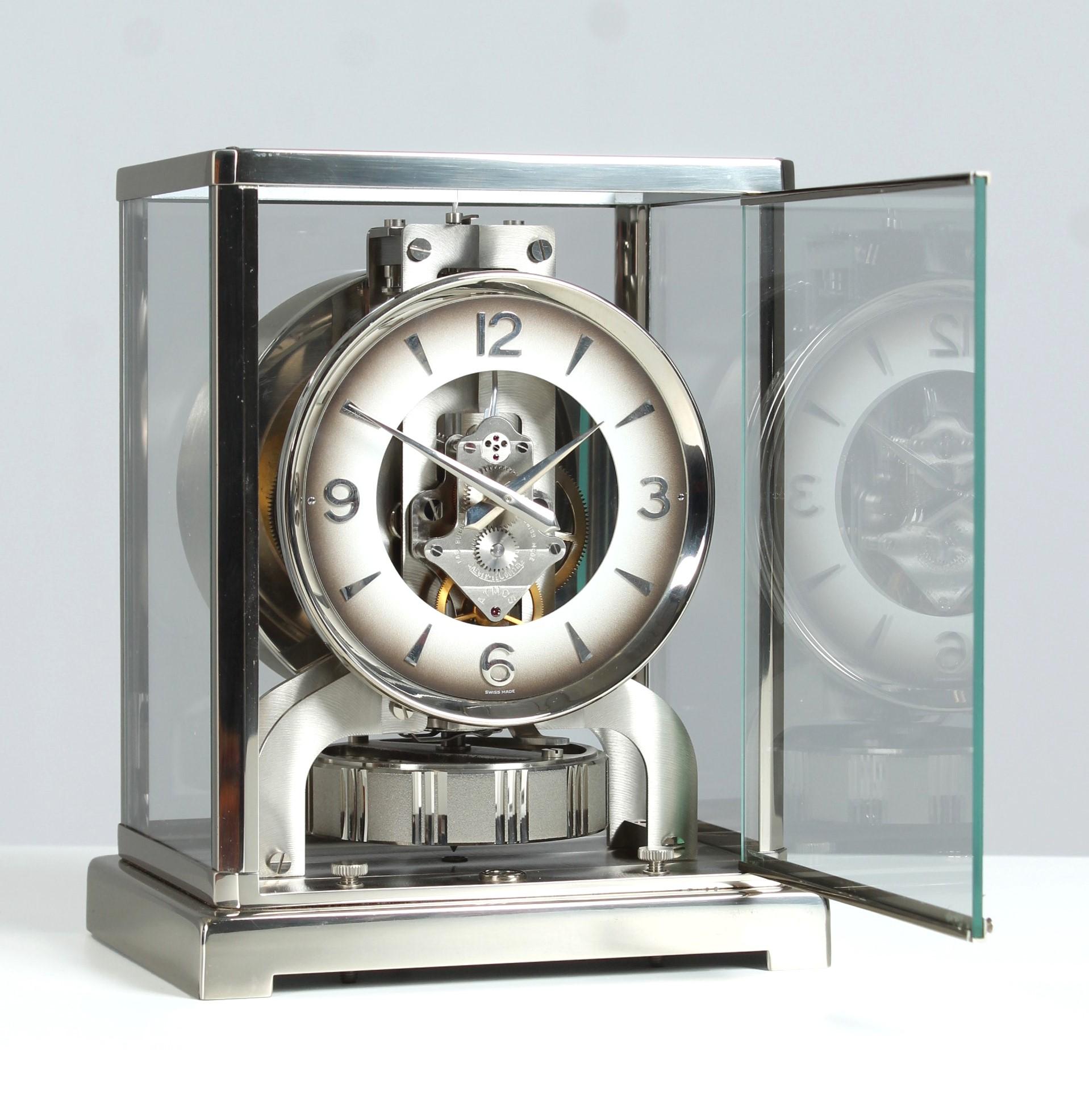 Silver Atmos table clock with smoky grey dial

Switzerland
Nickel-plated brass
Year of manufacture 1973

Dimensions: H x W x D: 22 x 18 x 13.5 cm

Description:
We are offering an Atmos V by Jaeger LeCoultre in an original nickel-plated case from