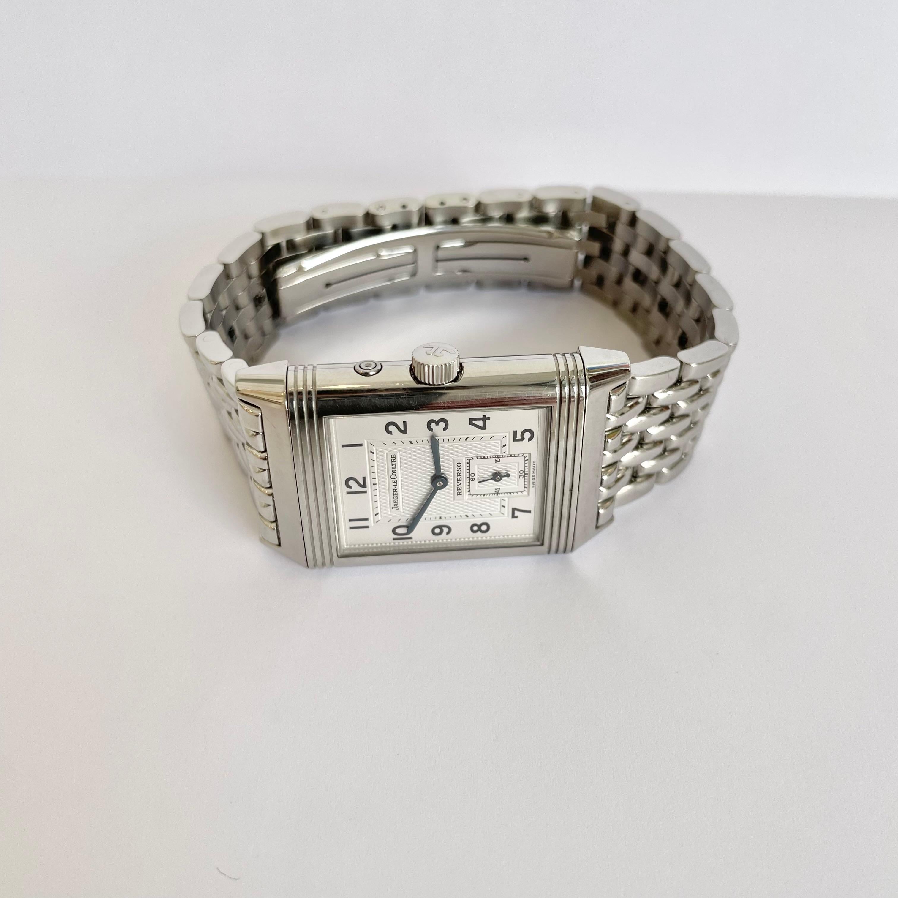 Elegant Jaeger-LeCoultre stainless steel Reverso wrist watch with a silver guilloché dial and a dark charcoal dial opposite. Manual, self-winding and water resistant up to 30 meters. A perfectly designed style with a link bracelet and clasp closure.