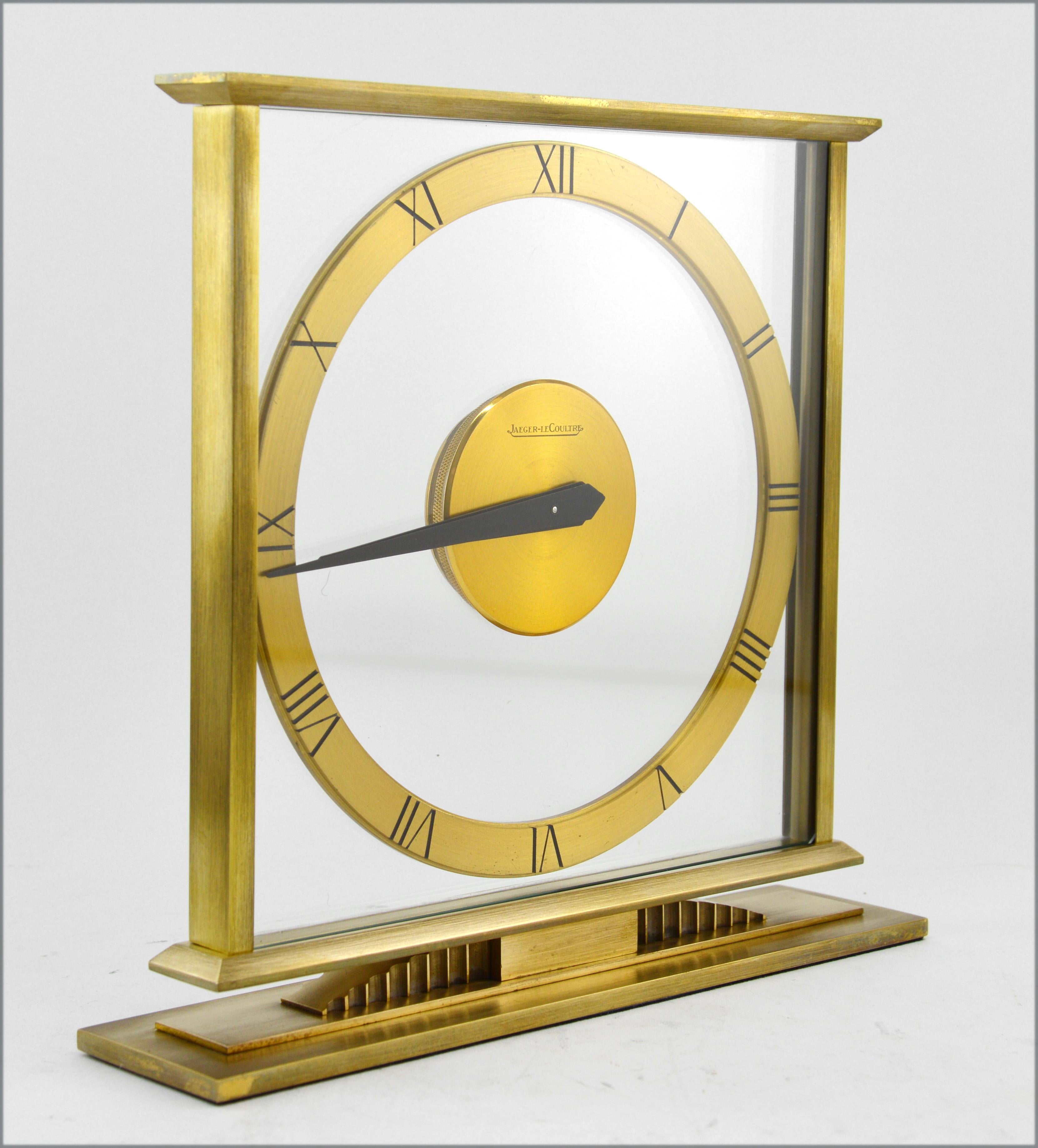 Midcentury table clock by Jaeger-LeCoultre, Switzerland, 1940s-1950s. Brass dial and body. Glass front plate. Plastic back plate. 8 days movement. Measures: Height 7.7