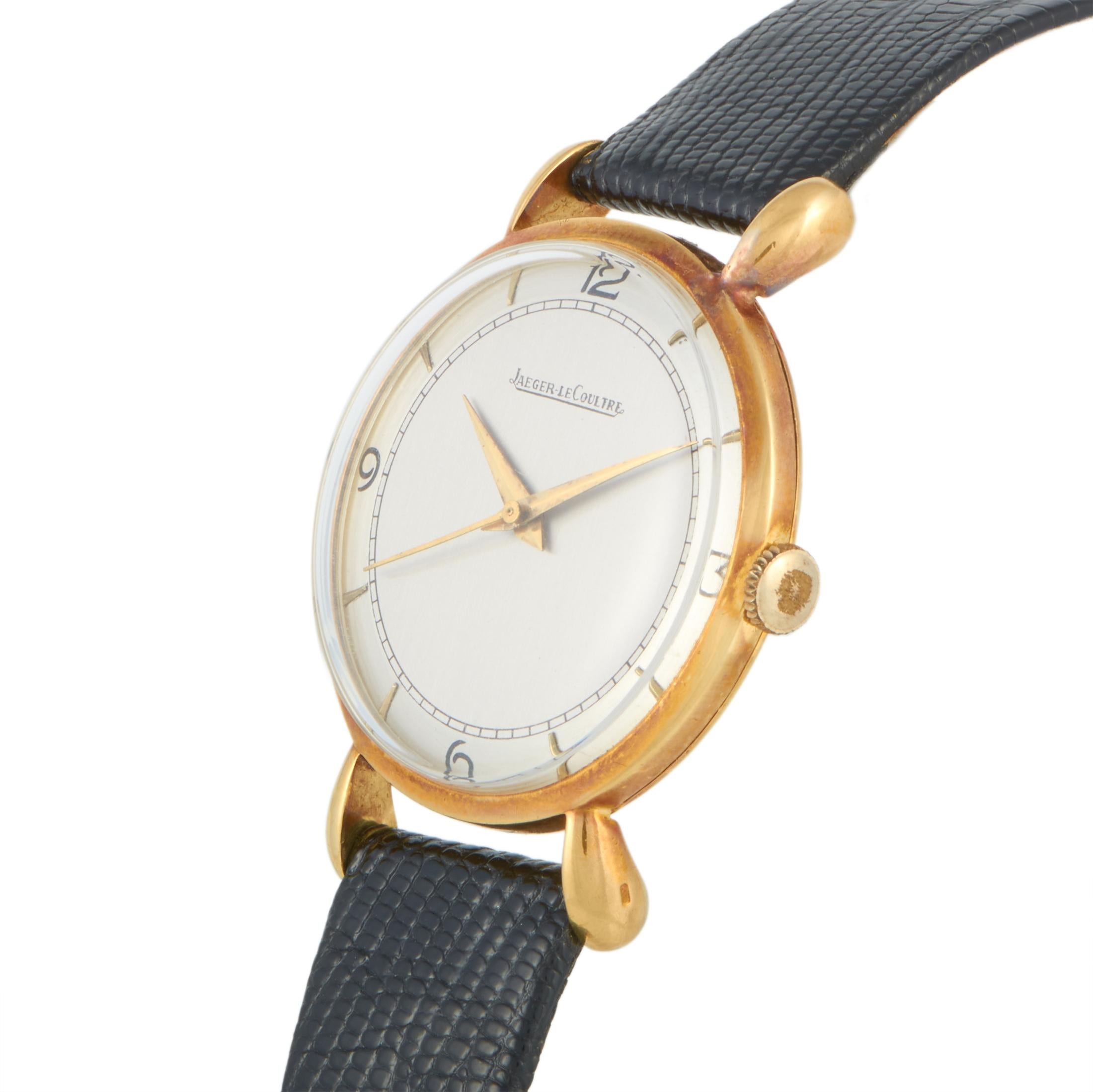 This vintage Jaeger-LeCoultre timepiece is presented with an 18K yellow gold case that measures 35 mm in diameter. The watch is equipped with a hand-wound movement and indicates hours, minutes and seconds on the silver dial. This model is worn on a