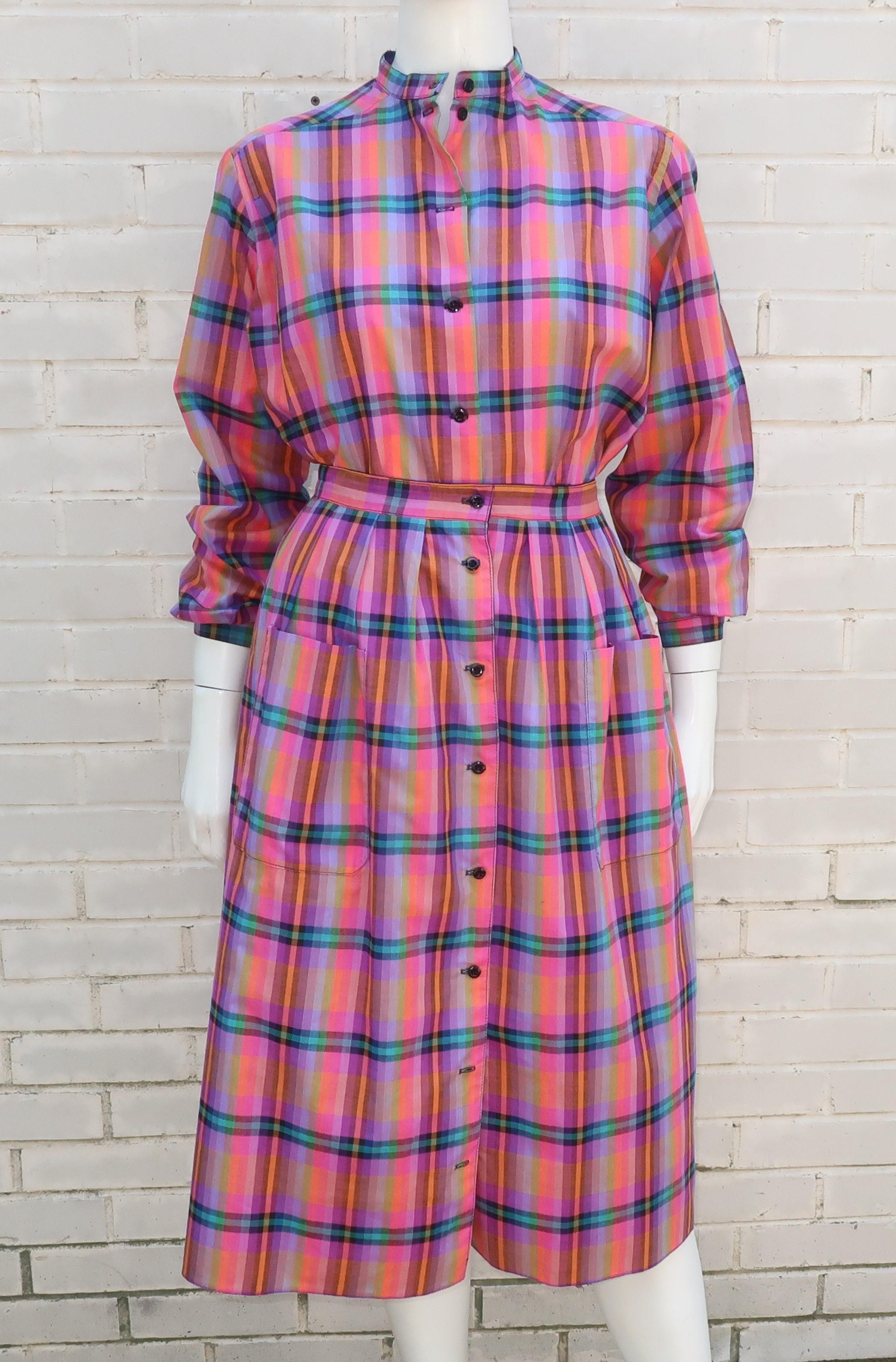 1970's Jaeger two piece shirt and skirt ensemble in a crisp cotton plaid with a vibrant combination of hot pink, orange, green, tan, purple and black.  The tab collar shirt buttons up the front with stitched pleats at the front shoulder and button