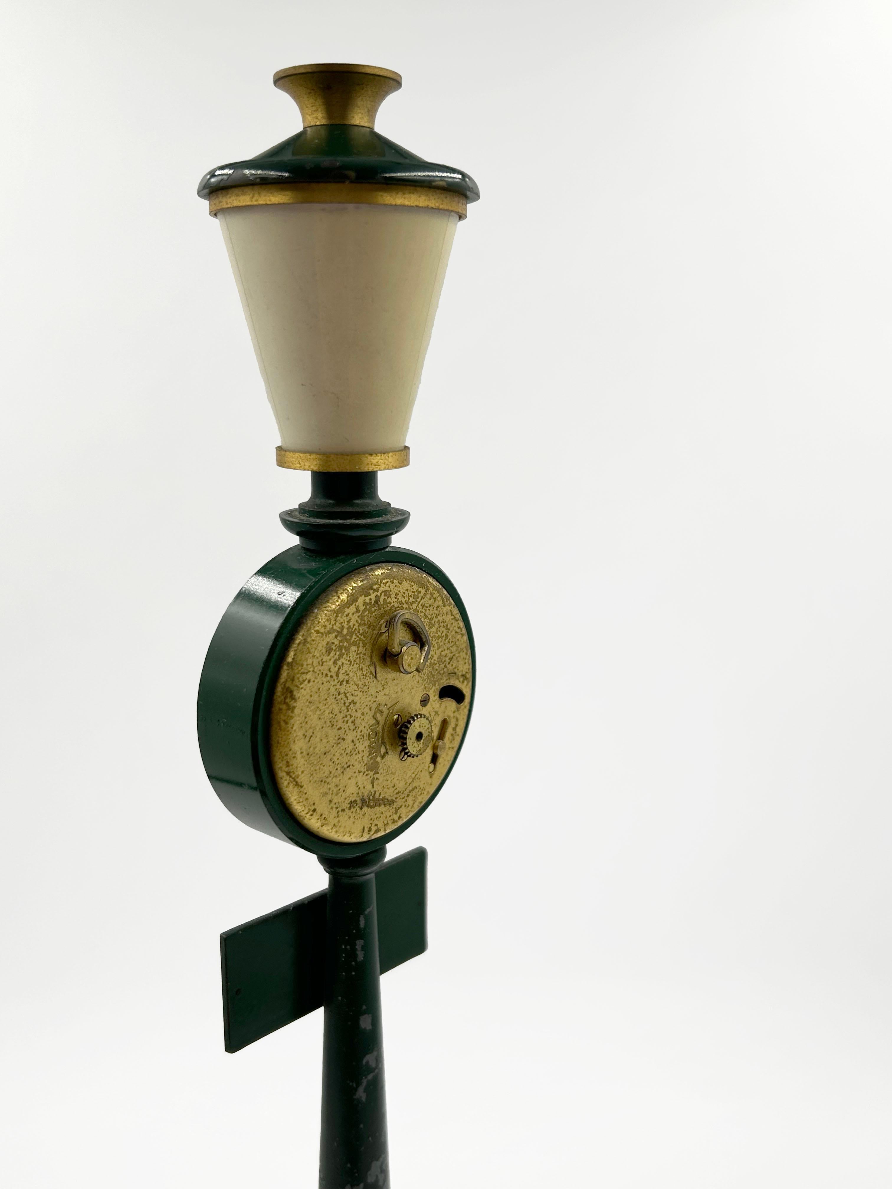 Jaeger “Rue de la Paix” Desk Clock, France, ca. 1960
Original decorative clock in the shape of a Parisian lantern, made of dark green enameled metal with gold details. The dial, with Roman numerals and ornate hands, bears the Jaeger signature. On