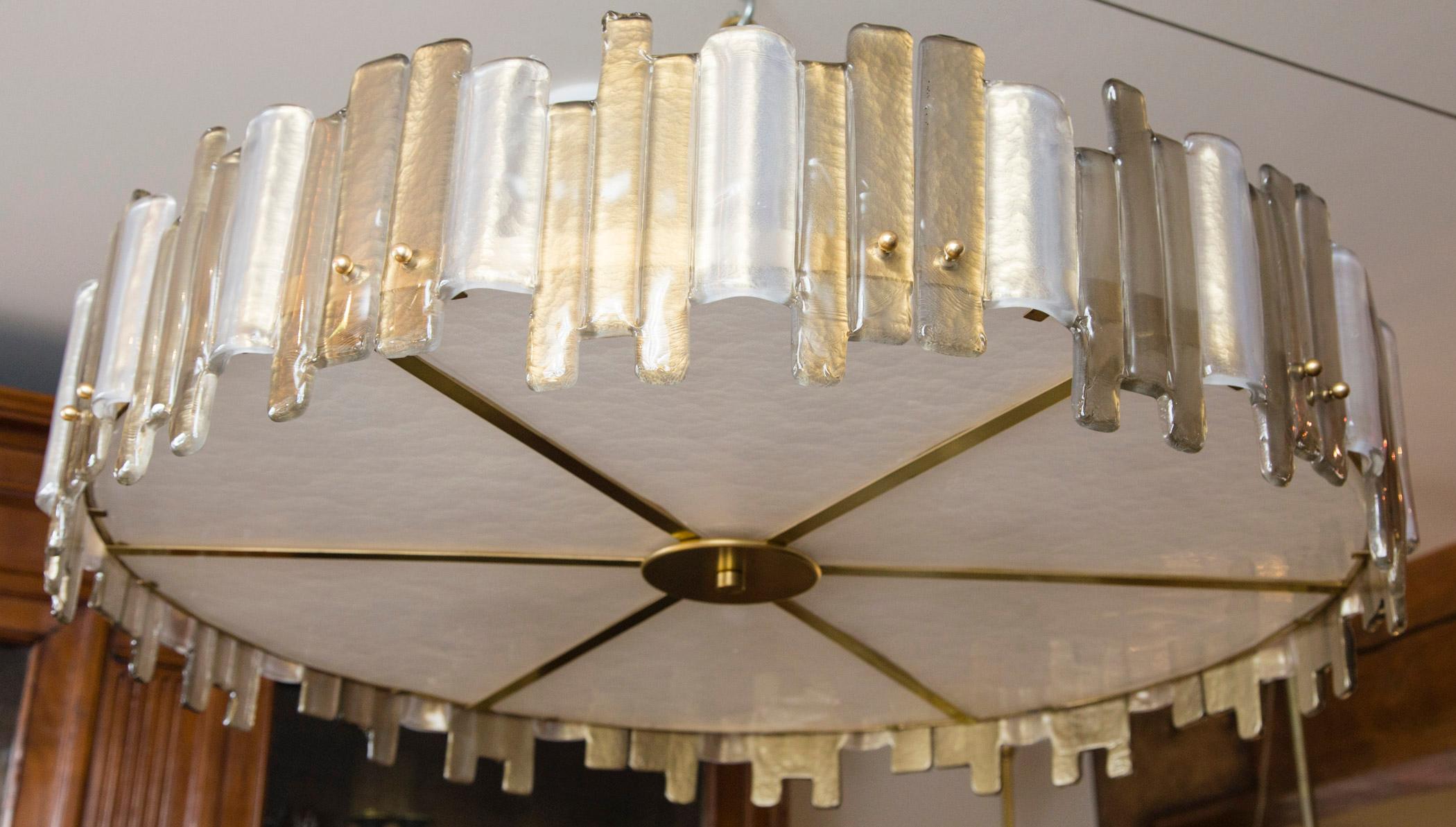 A Minimalist brass drum-shaped ceiling fixture with Murano blown jagged rectangular forms fused together in taupe and opaque white, diffusor composed of thickly blown pearled opaque and textured glass, electrified to code, illuminated with six