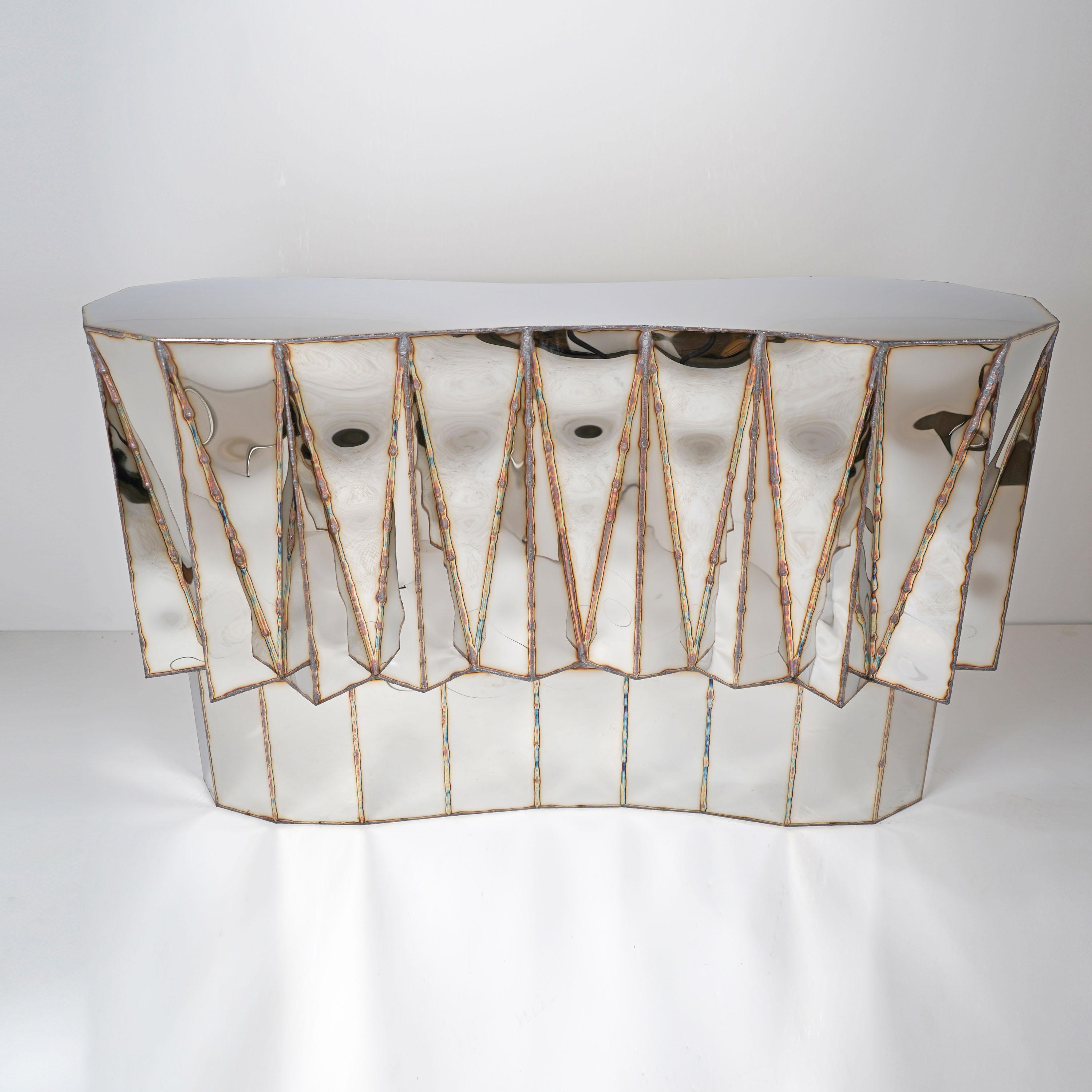 Jagged Edge Bar in Welded Mirror Polish & Stainless Steel by Julian Mayor
Limited Edition of 5 + 2AP.
Dimensions: D 46 x W 151 x H 90 cm. 
Materials: Mirror polish and stainless steel.

Julian Mayor is a British artist and designer renowned for his