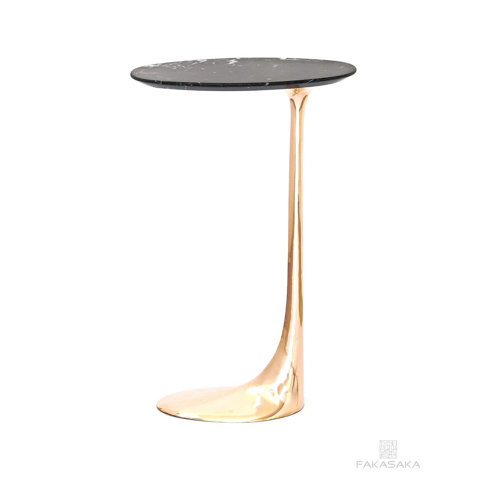 Jagger drink table with Nero Marquina Marble top by Fakasaka Design.
Dimensions: W 18 cm D 38 cm H 62 cm
Materials: polished bronze base, Nero Marquina marble top.
Also available in dark bronze. 

 FAKASAKA is a design company focused on