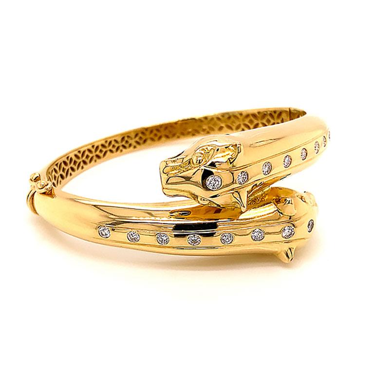 Ce bracelet est composé de deux têtes de jaguar aux extrémités opposées se croisant en or jaune 18 carats. Avec un total de 16 diamants ronds de taille brillant, 8 descendant sur chaque tête des jaguars. Les diamants sont de couleur G et de pureté