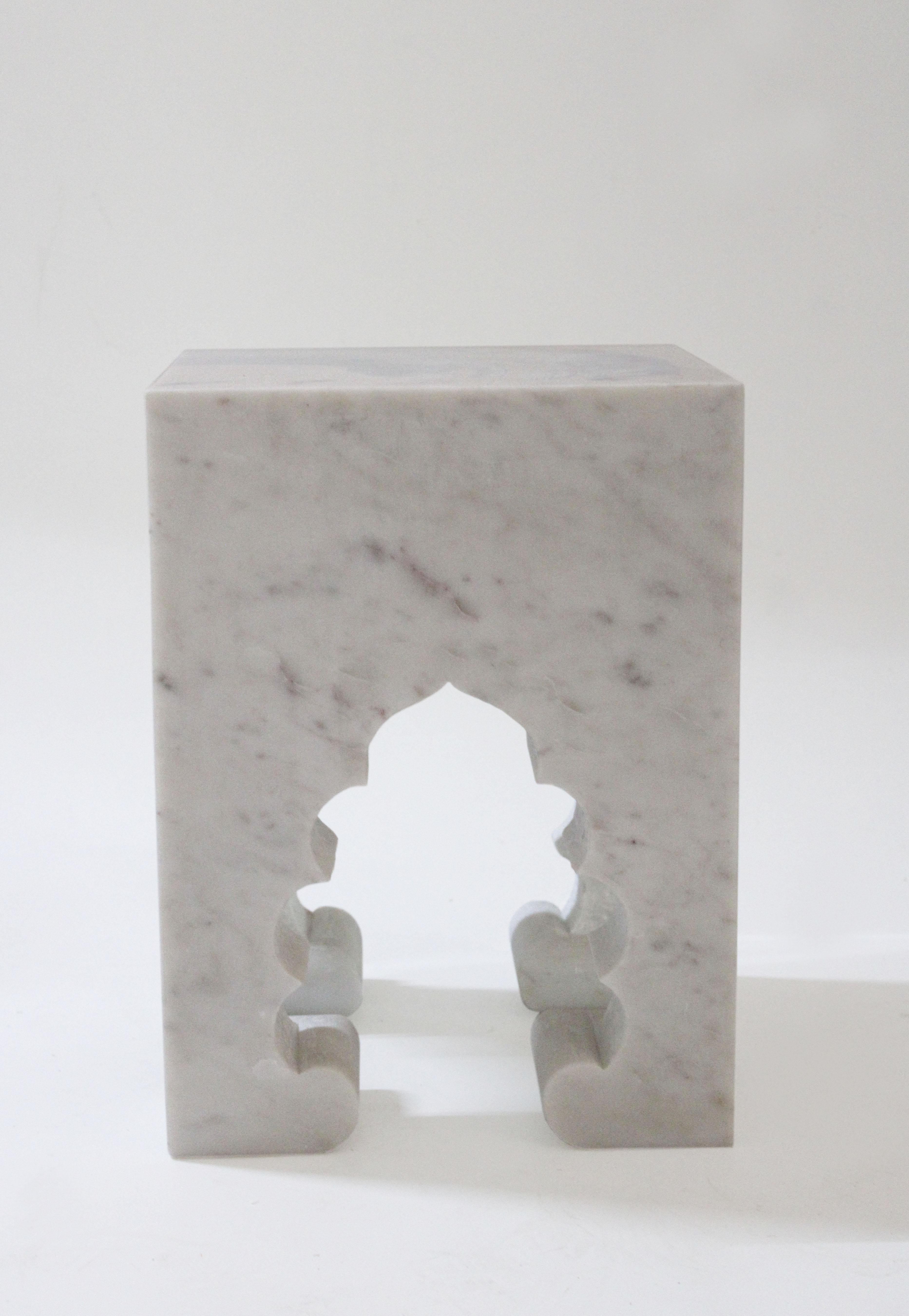 Inspired by the elegant architectural element, namely the mehrabs, he saw in the palaces of Mughal India, the renowned designer Paul Mathieu has created this unique hand-carved side table. Solid blocks of marble are hand-carved into low elegant