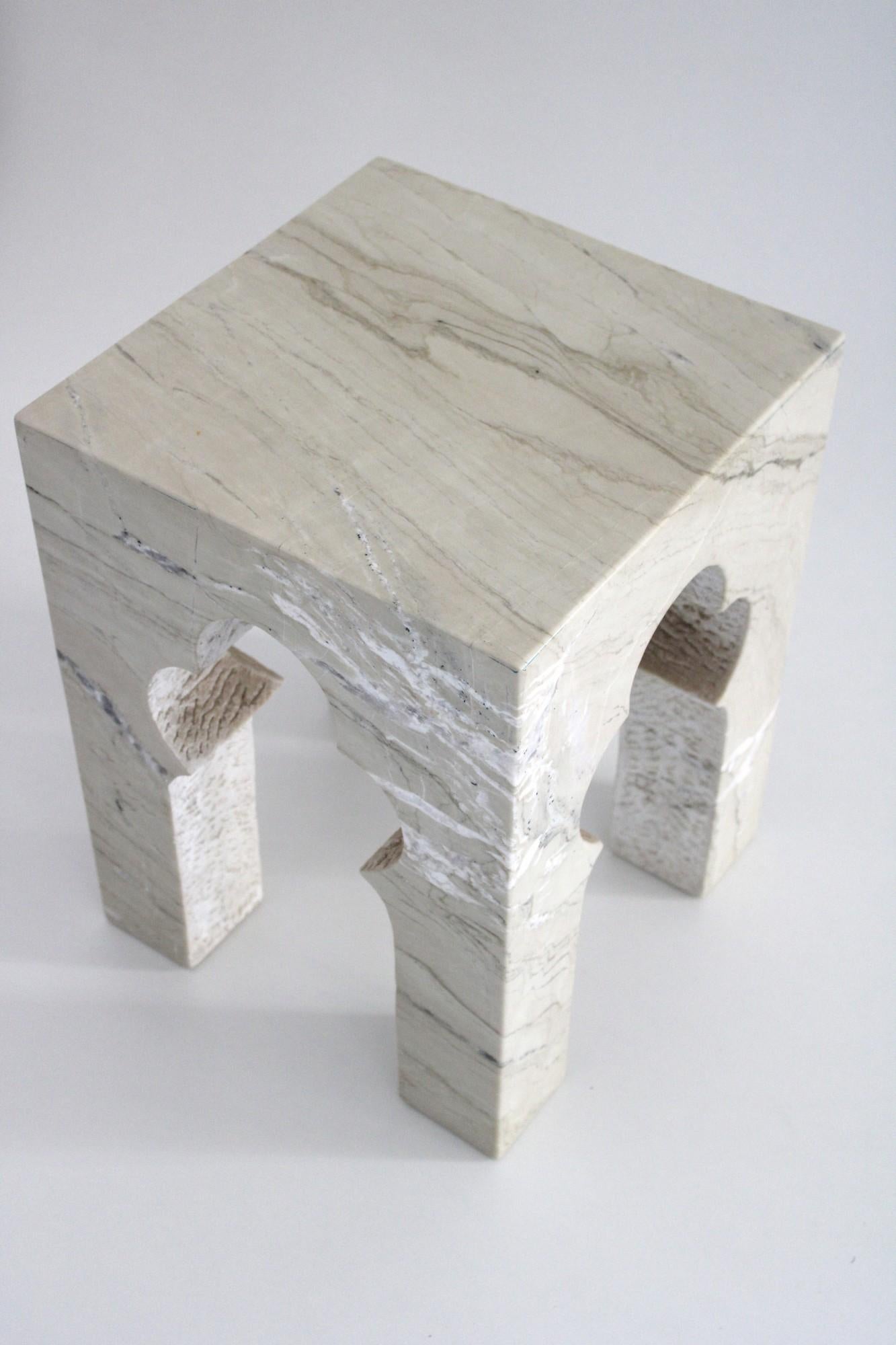 Inspired by the elegant architectural element, namely the mehrabs, he saw in the palaces of Mughal India, the renowned designer Paul Mathieu has created this unique hand-carved side table. Solid blocks of marble are hand-carved into low elegant