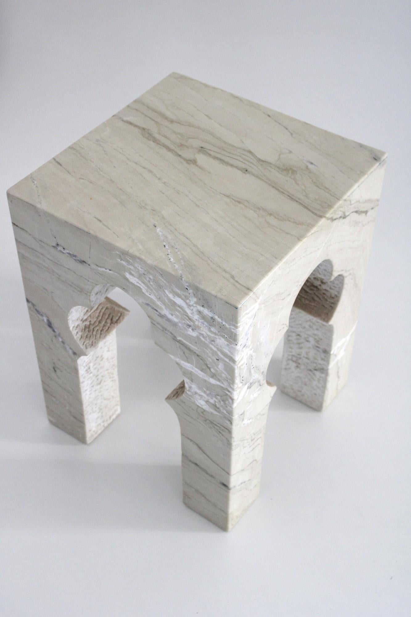 Inspired by the elegant architectural element, namely the mehrabs, he saw in the palaces of Mughal India, the renowned designer Paul Mathieu has created this unique hand-carved side table. Solid blocks of marble are hand-carved into low elegant