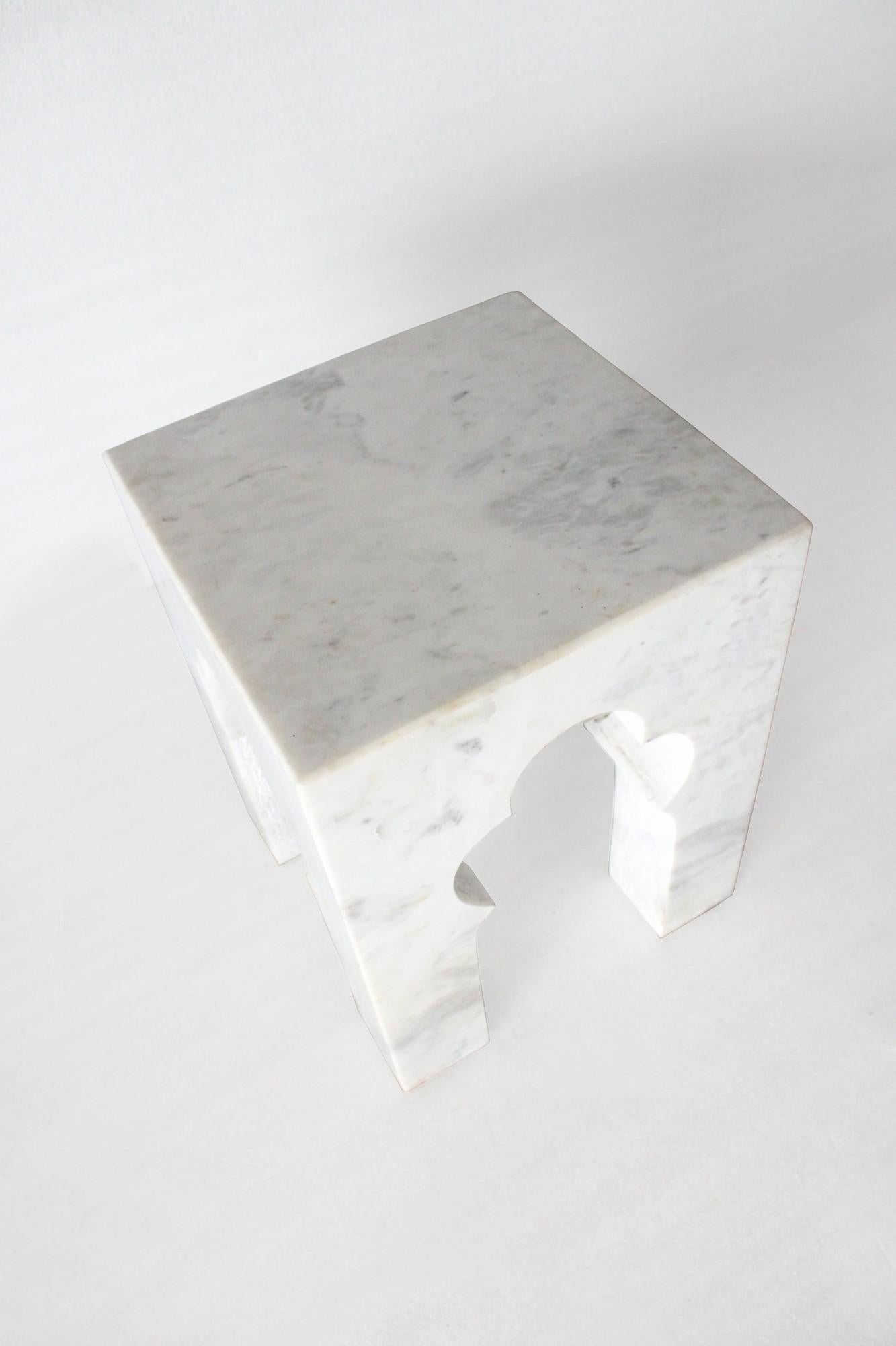 Inspired by the elegant architectural element, namely the mehrabs, he saw in the palaces of Mughal India, the renowned designer Paul Mathieu has created this unique hand-carved side table. Solid blocks of marble are hand-carved into low elegant