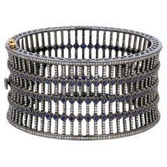 Manchette style barre de jail avec diamants et saphirs en or 14 carats