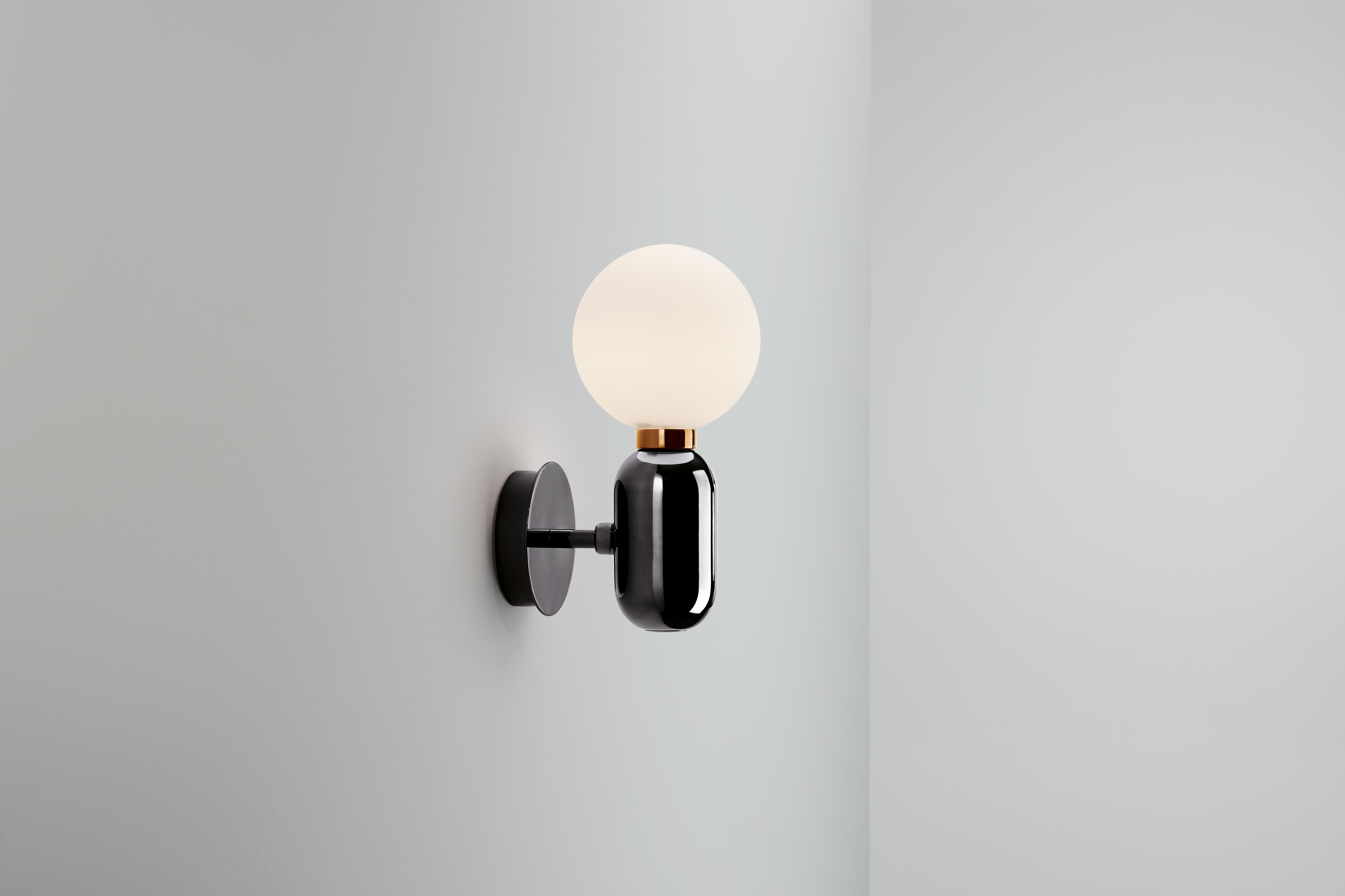 Lámpara de pared, modelo Aballs A, diseñada por Jaime Hayon en 2013.
Fabricado por Parachilna.
Cuerpo de cerámica negra hecho a mano y difusor de vidrio soplado opal mate.
La base también está disponible en cerámica blanca, dorada, cobre o