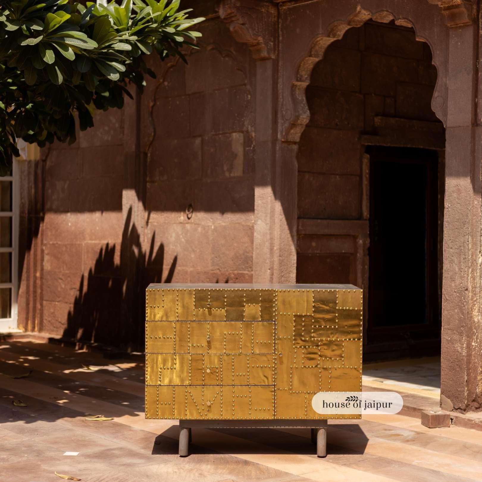 A timeless blend of craftsmanship and grandeur, This Jaipur Brass Patchwork Sideboard is handcrafted from solid wood and clad in hand-fitted brass sheets, each detailed with rivet-like embossing that reflects warmth and artistry. The subtle patina