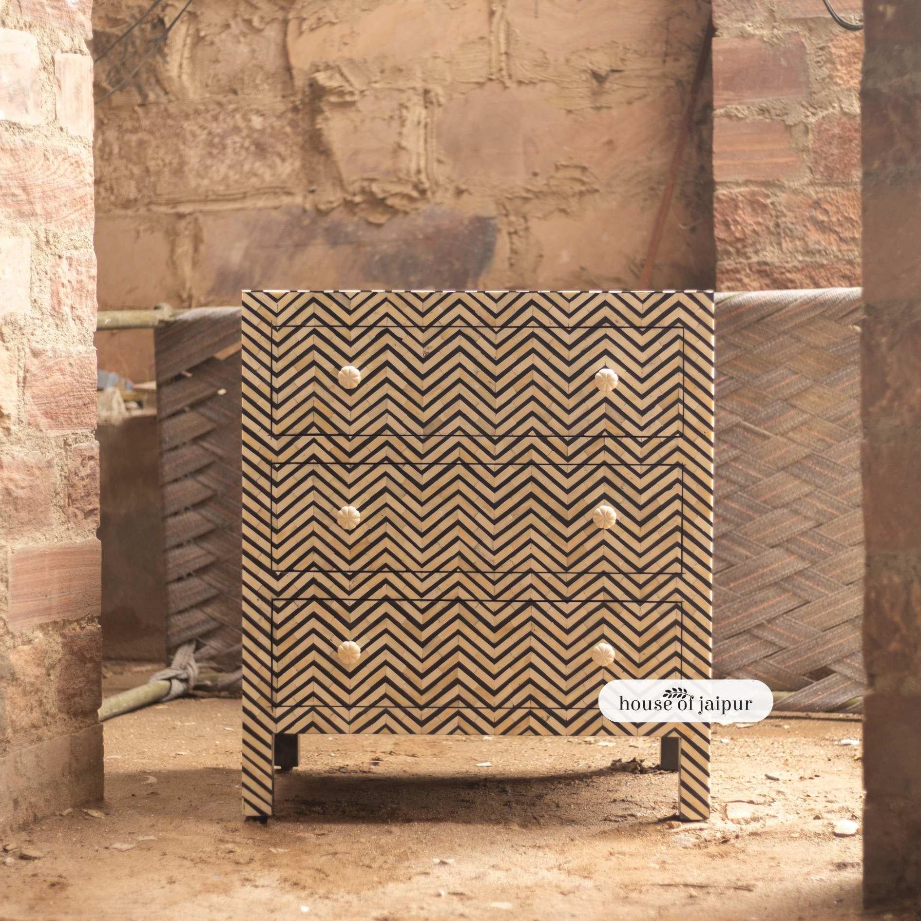 Questo elegante comò con intarsi in osso chevron mostra la perfetta armonia tra la geometria moderna e l'arte indiana senza tempo. Ogni pezzo d'osso è tagliato, modellato e incastonato a mano in un sorprendente motivo a zig zag su una base liscia di