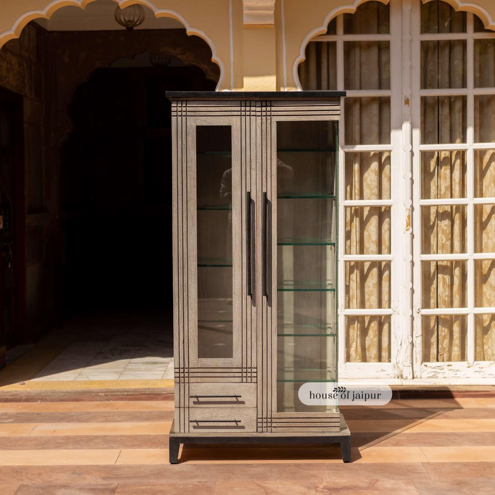 L'espositore Jaipur Distressed Linea della Collection'S incarna un'artigianalità raffinata e una grazia architettonica. Realizzato a mano in legno massiccio, presenta una scocca grigia e consumata in contrasto con il piano e la base neri e lucidi,