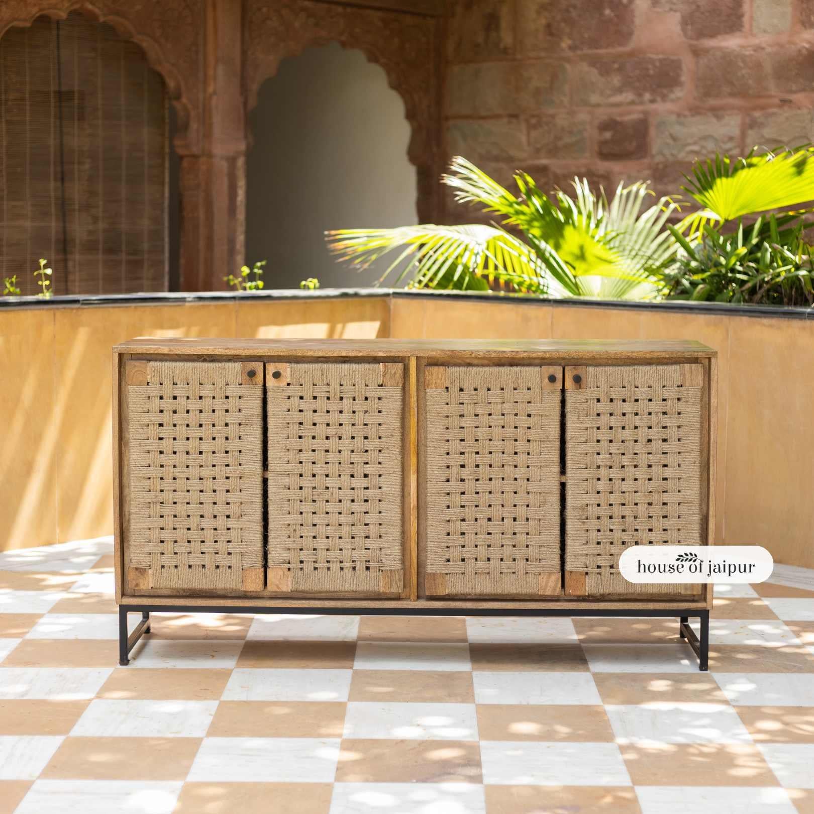 La credenza buffet in iuta intrecciata a mano di Elegance è un capolavoro di eleganza artigianale, che unisce la consistenza naturale a un design funzionale. Realizzata in legno massiccio e poggiata su una robusta base in metallo nero, questa