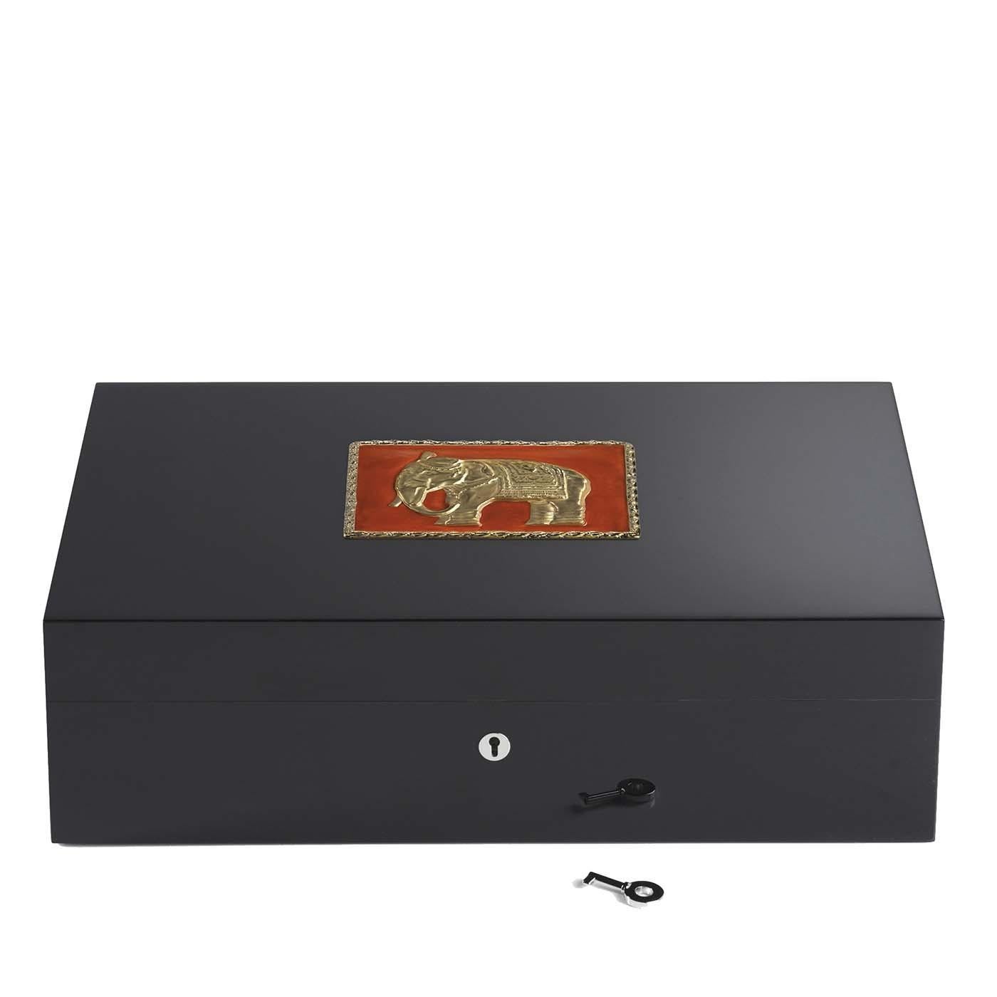 Named after one of the Indian states known for elephants, this exquisite wooden humidor contains up to 110 cigars. The decoration on top of the lid features a red background, with golden edges and the reproduction of an elephant in the same finish.