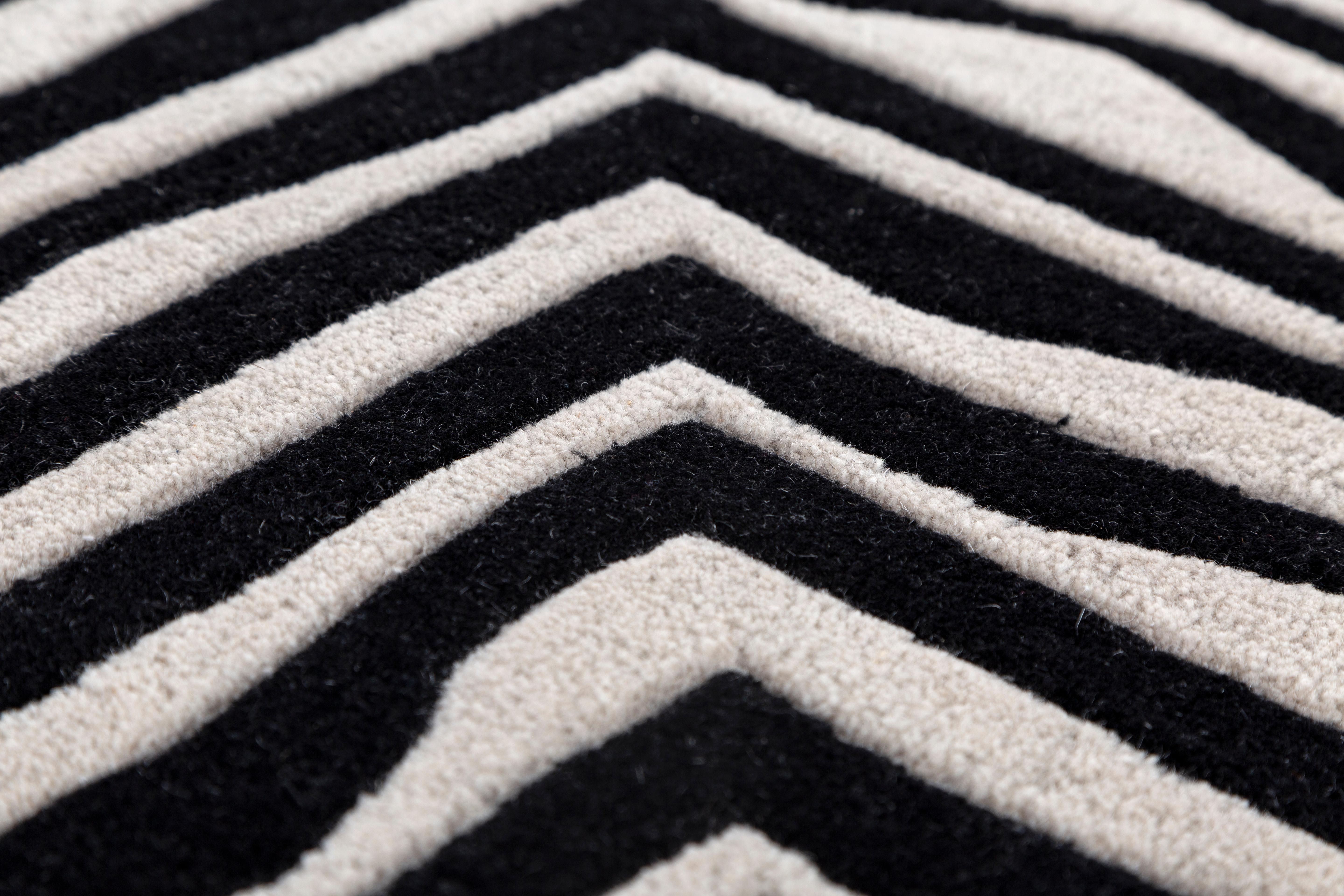 Jaipur Rugs Die Adrift Collection ist eine kühne Erkundung der Kontraste, bei der auffällige Schwarz-Weiß-Muster die Grundlage für jedes Stück bilden. Diese monochromen Elemente sorgen für eine starke, zeitlose Aussage, während kräftige Farbtupfer