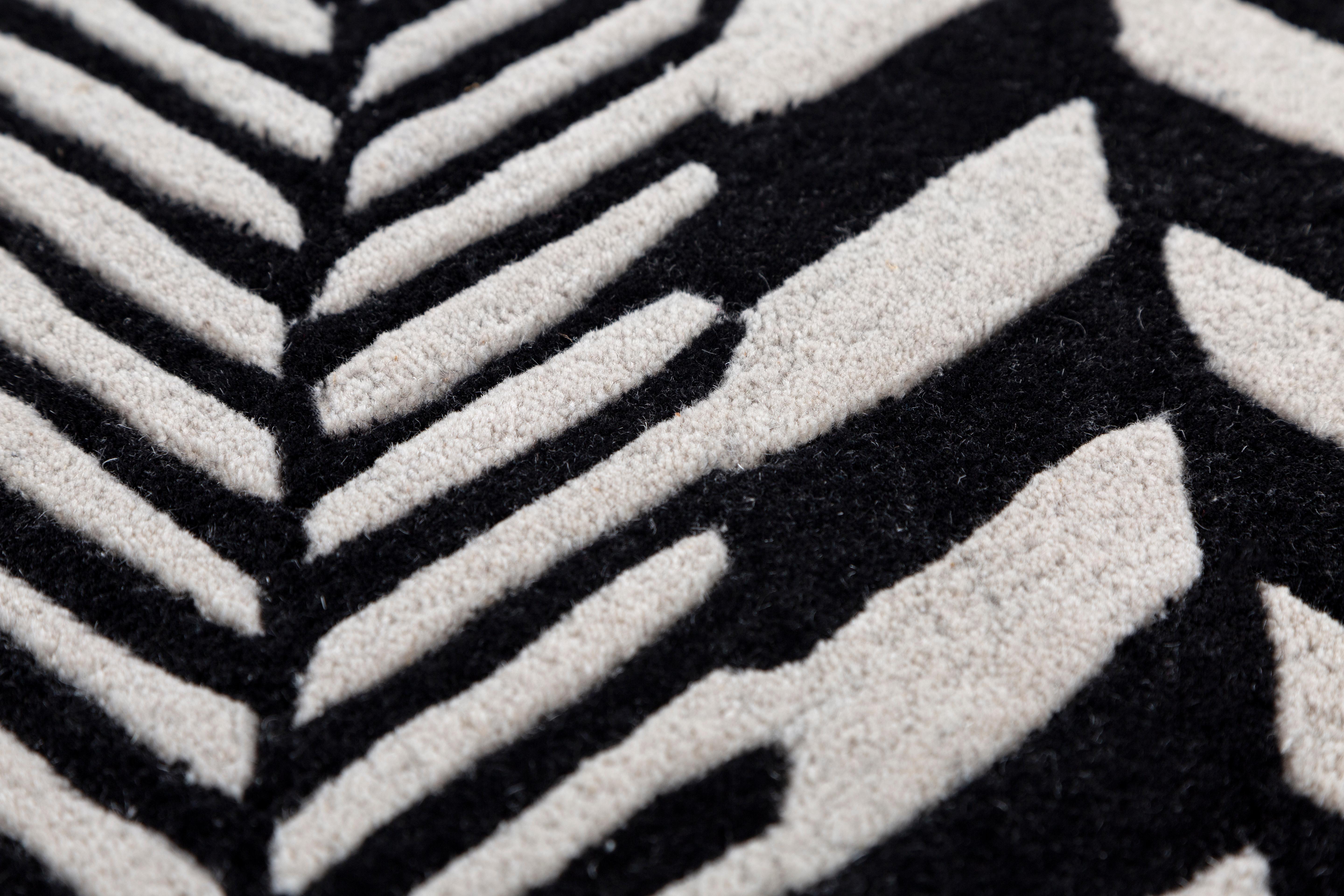 Jaipur Rugs Die Adrift Collection ist eine kühne Erkundung der Kontraste, bei der auffällige Schwarz-Weiß-Muster die Grundlage für jedes Stück bilden. Diese monochromen Elemente sorgen für eine starke, zeitlose Aussage, während kräftige Farbtupfer