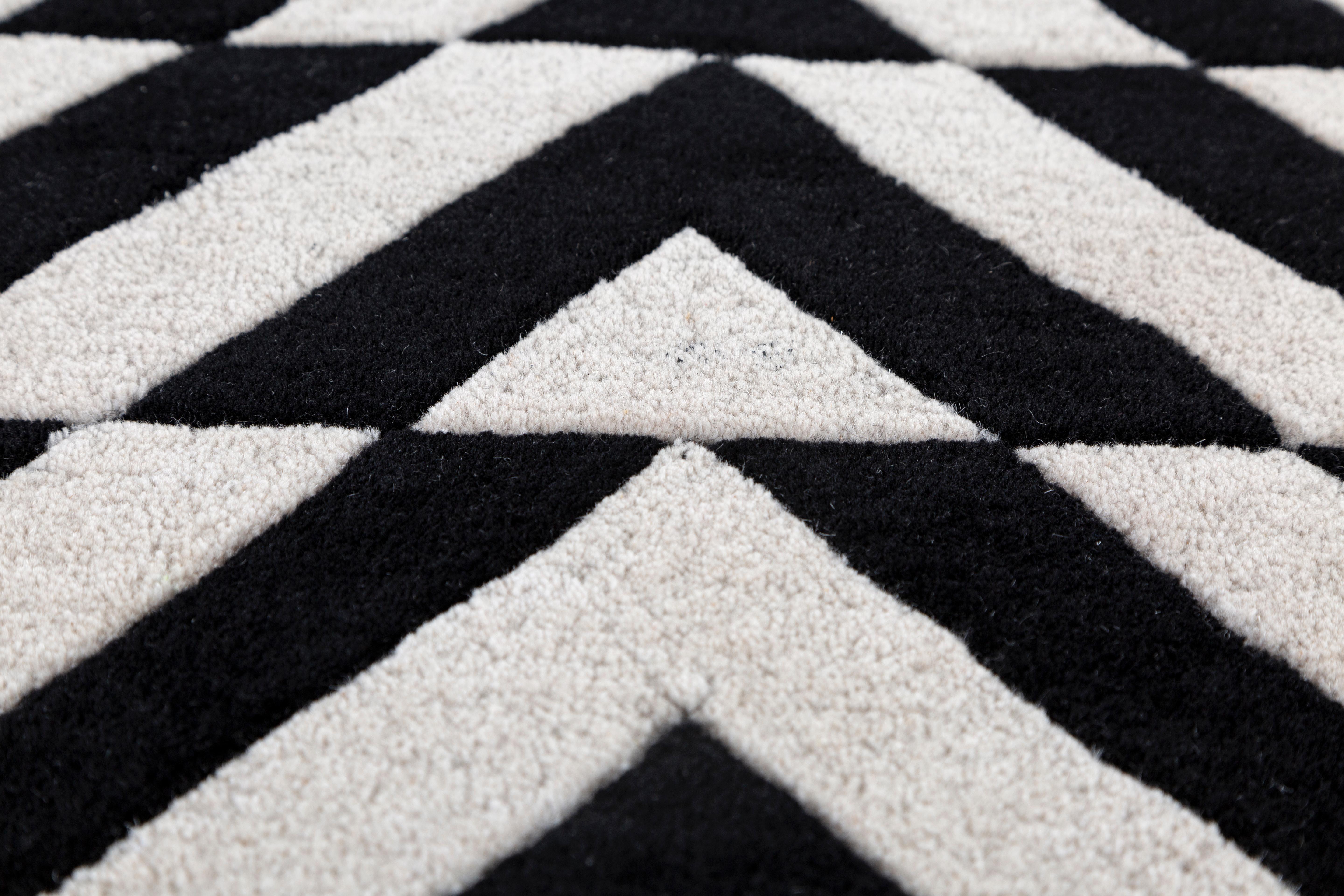 Jaipur Rugs Die Adrift Collection ist eine kühne Erkundung der Kontraste, bei der auffällige Schwarz-Weiß-Muster die Grundlage für jedes Stück bilden. Diese monochromen Elemente sorgen für eine starke, zeitlose Aussage, während kräftige Farbtupfer