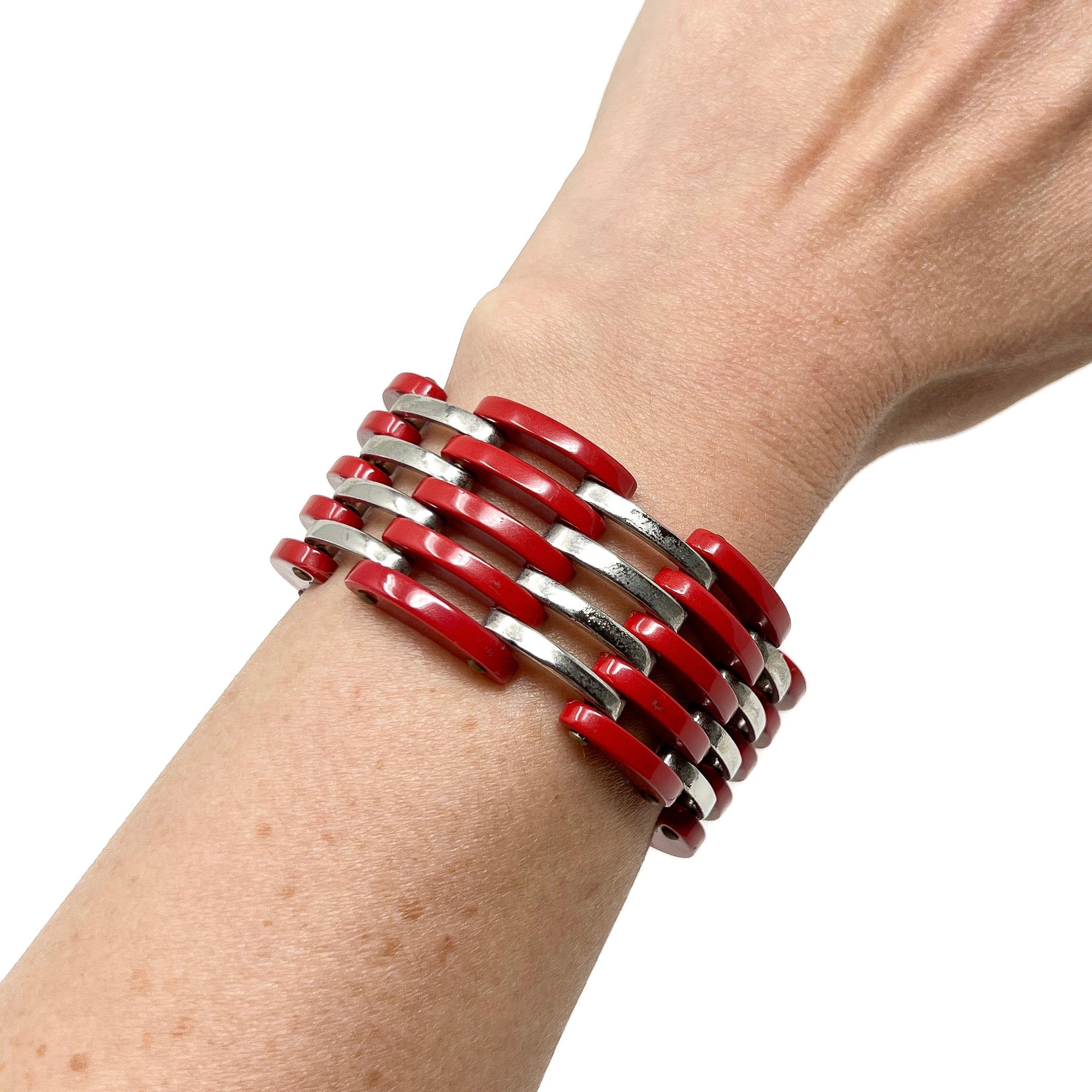 Ce bracelet élégant date des années 1930 et a été créé par Jakob Bengel. 

Rapport de condition :
Excellent 

Les détails...
Ce bracelet est composé de métal chromé et de panneaux incurvés en galalithe rouge, reliés entre eux par des rivets. Le